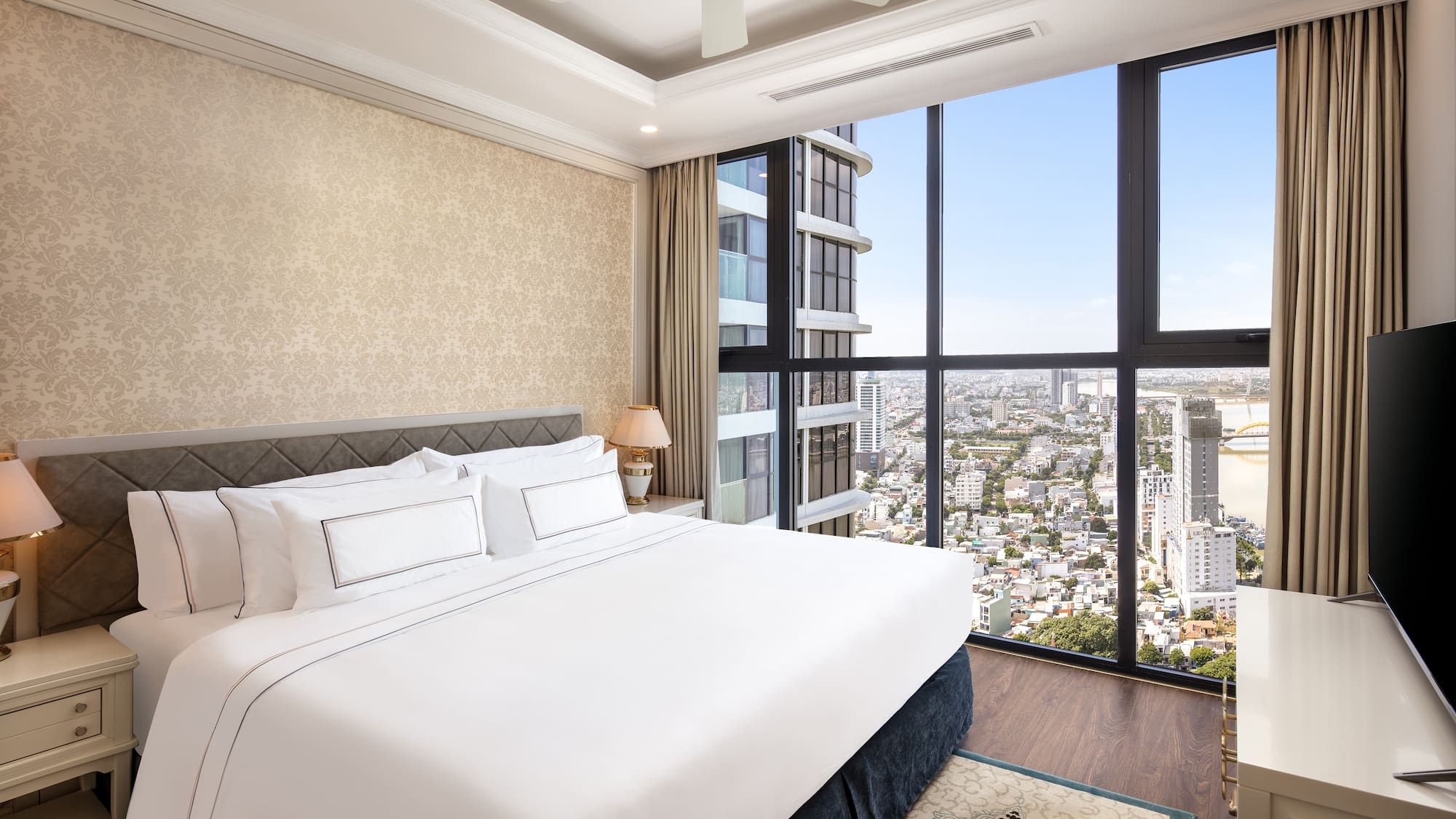a bedroom with a large window overlooking a city