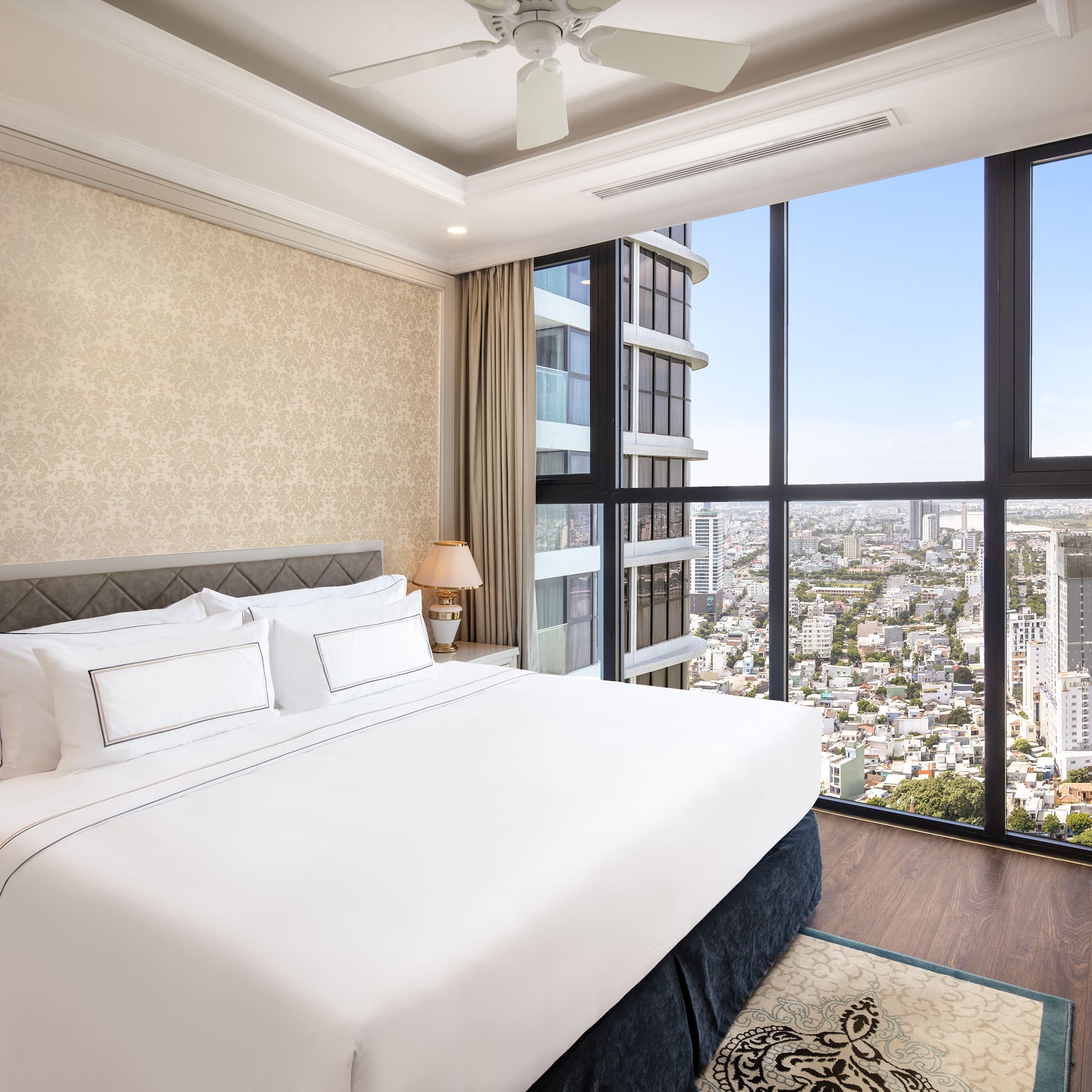 a bedroom with a large window overlooking a city