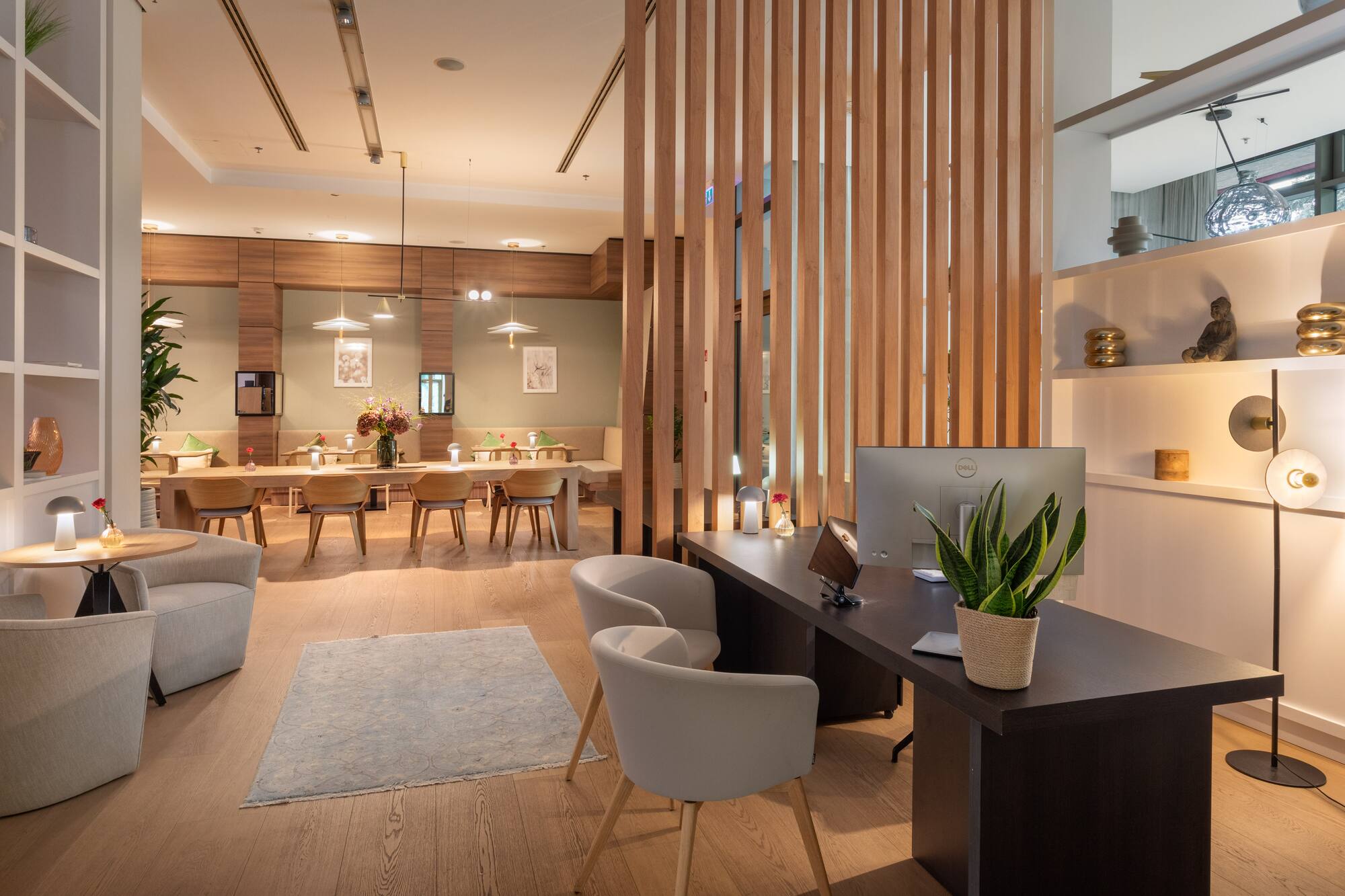 Modern hotel lobby with reception desk, lounge seating, and dining area.