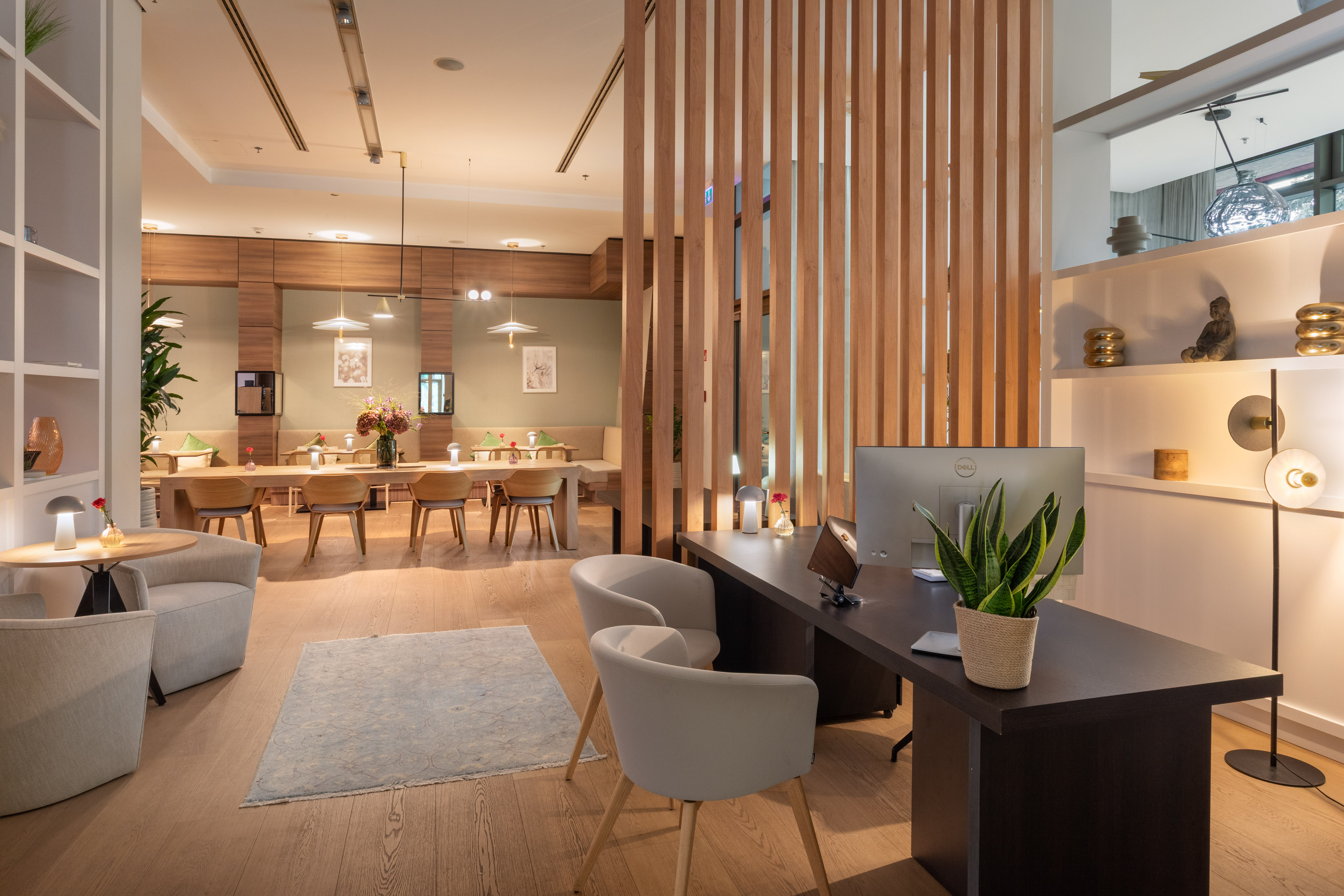 Modern hotel lobby with reception desk, lounge seating, and dining area.