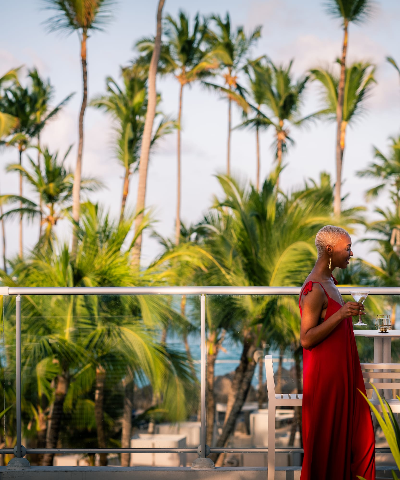 a group of women standing on a balcony with palm trees