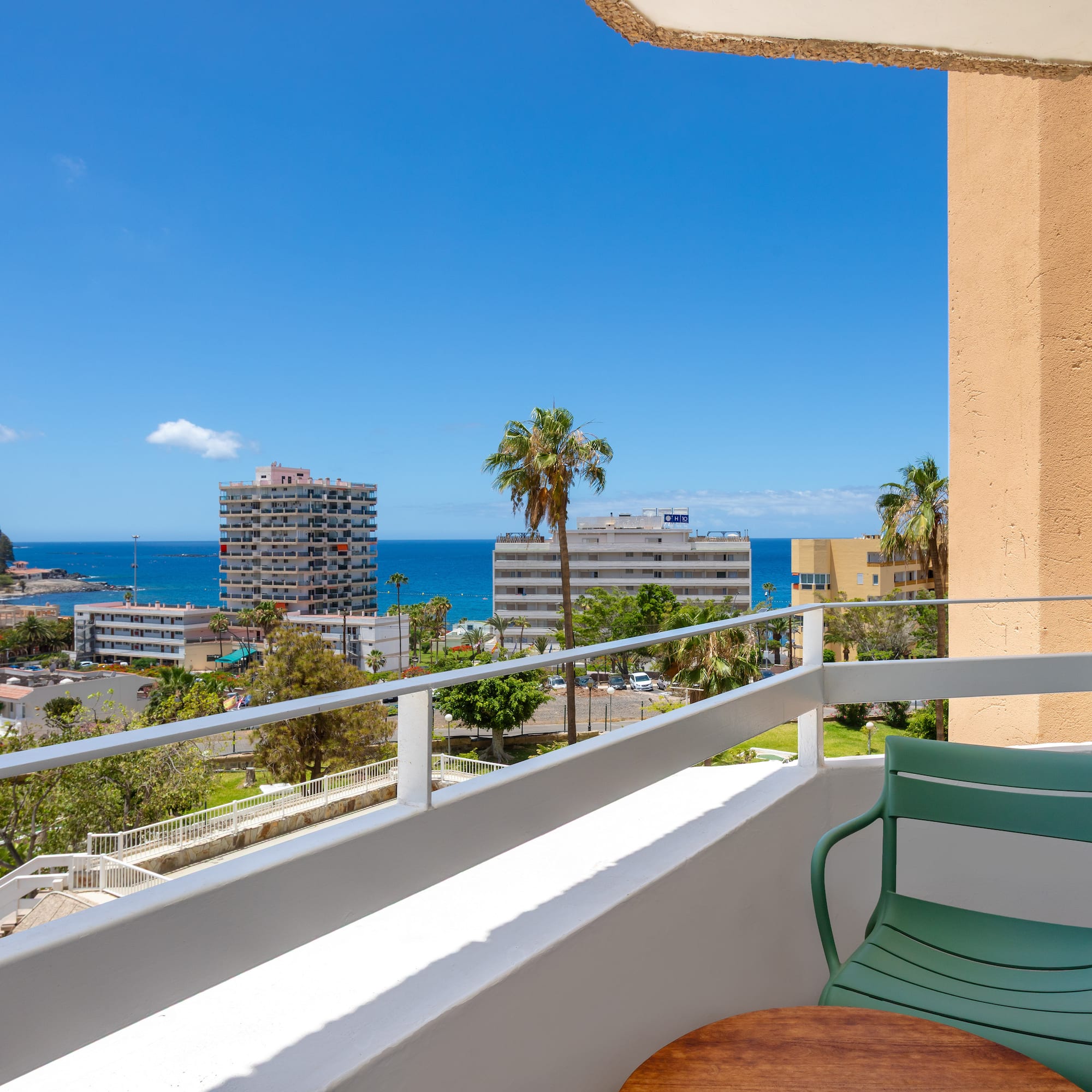a balcony with a chair and table overlooking a body of water