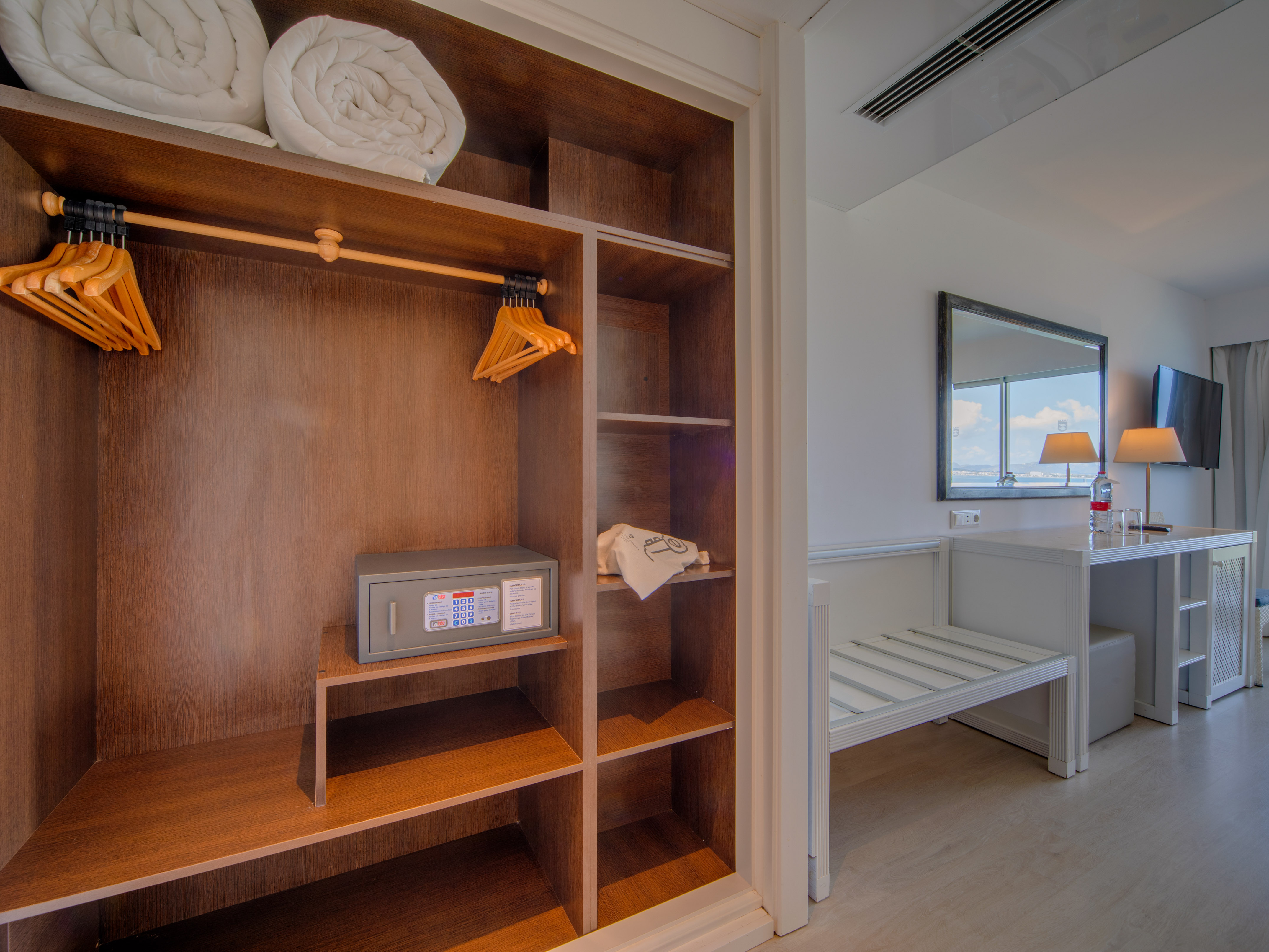 a closet with towels and a mirror