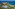 a beach with trees and buildings and a body of water