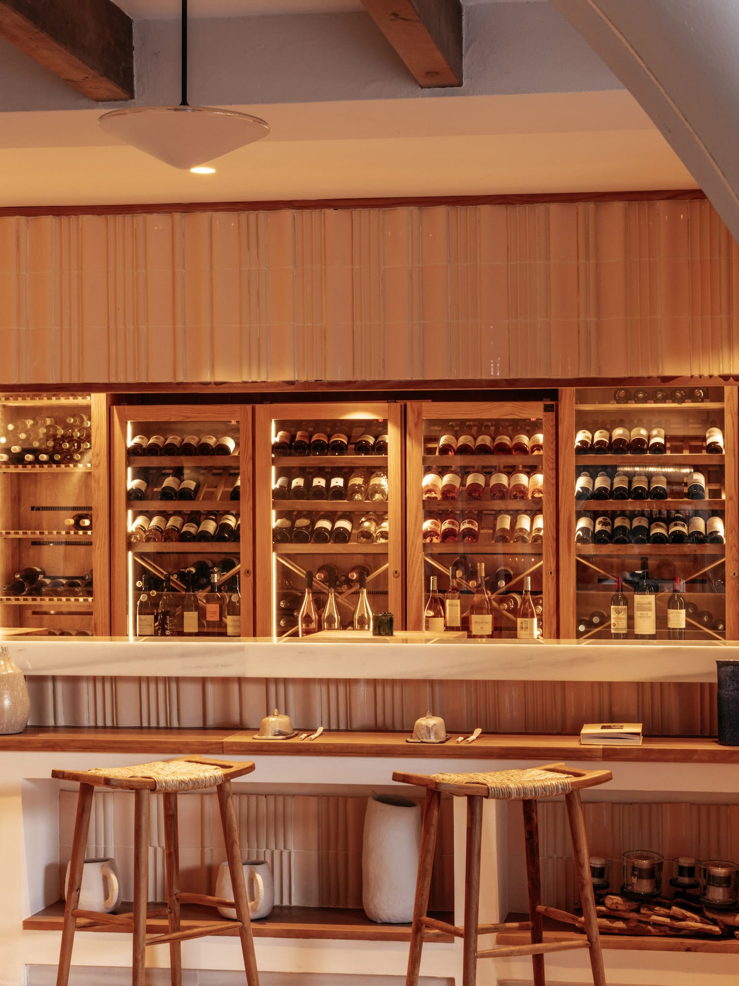 a bar with shelves of wine and stools