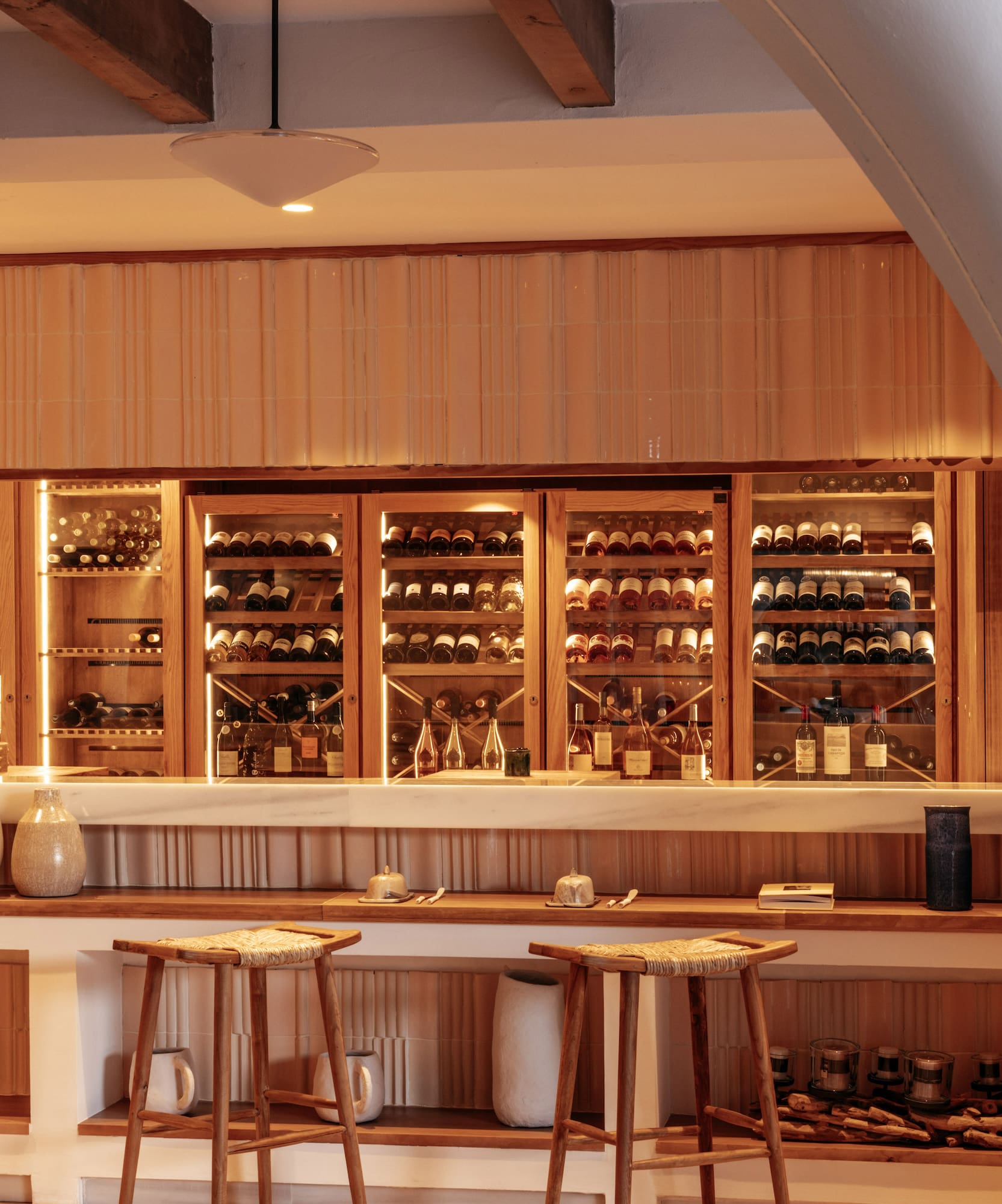 a bar with shelves of wine and stools