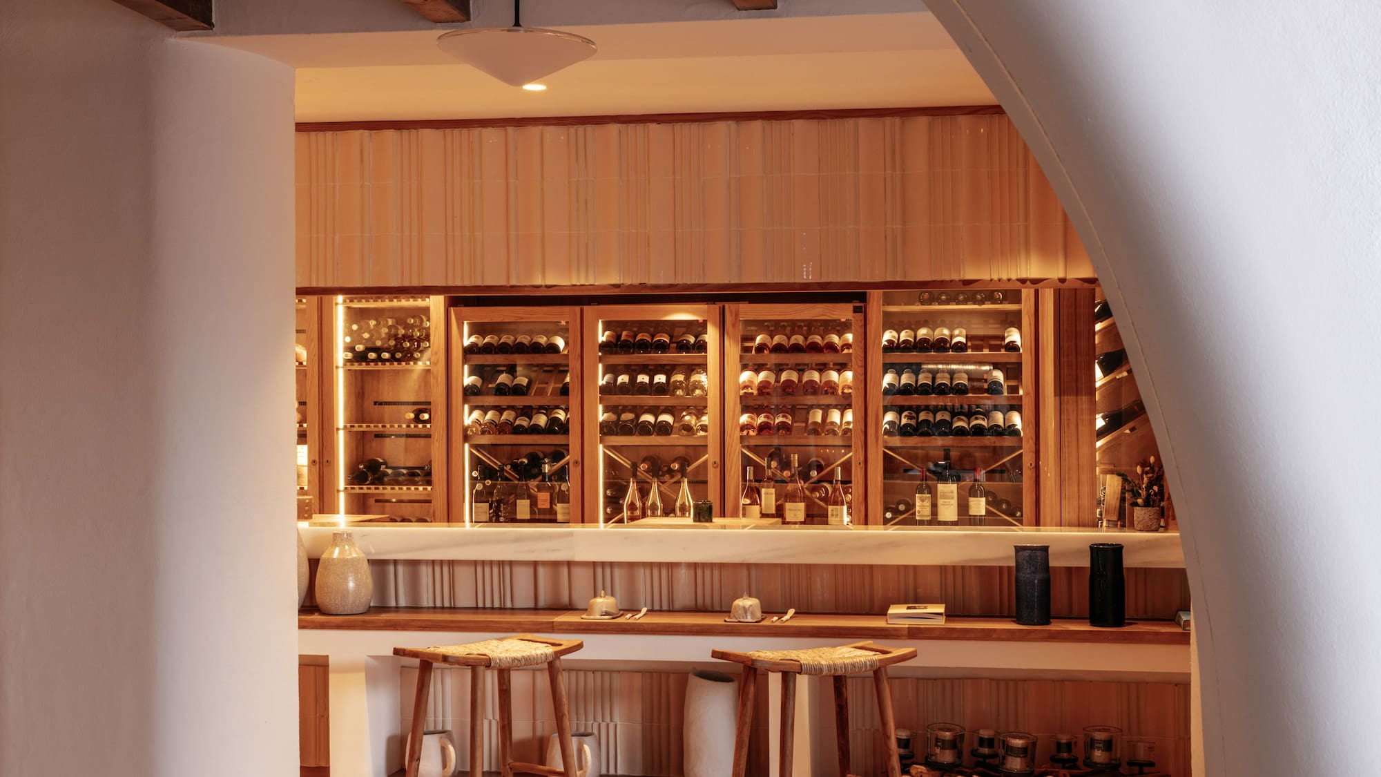 a bar with shelves of wine and stools