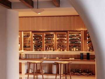 a bar with shelves of wine and stools