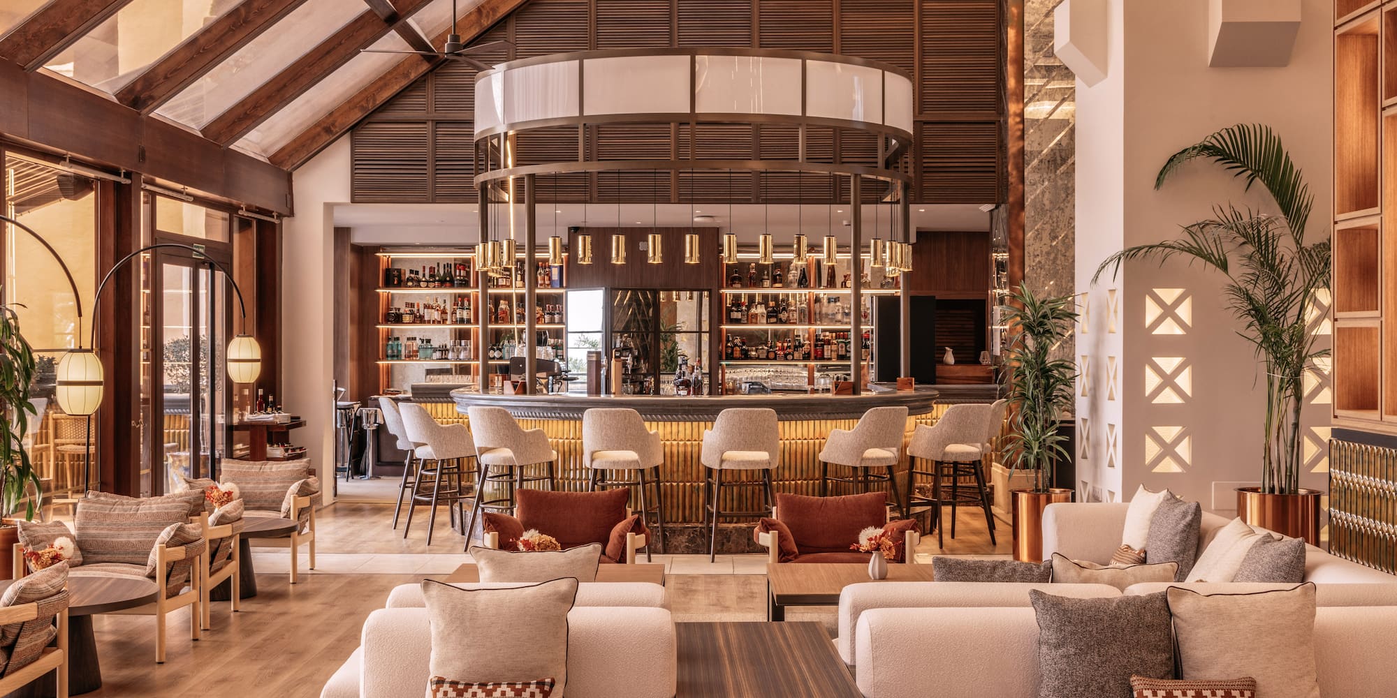 Luxury hotel bar and lounge, circular bar, plush seating, high wooden ceiling.