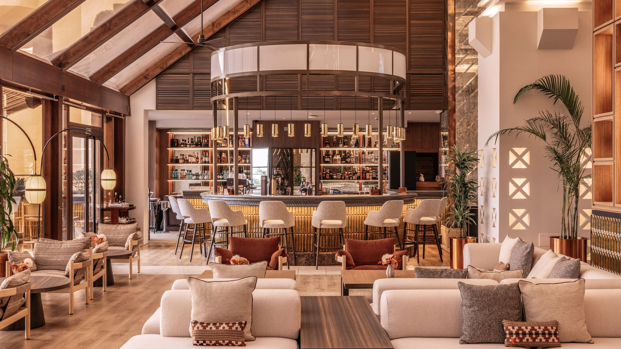 Luxury hotel bar and lounge, circular bar, plush seating, high wooden ceiling.