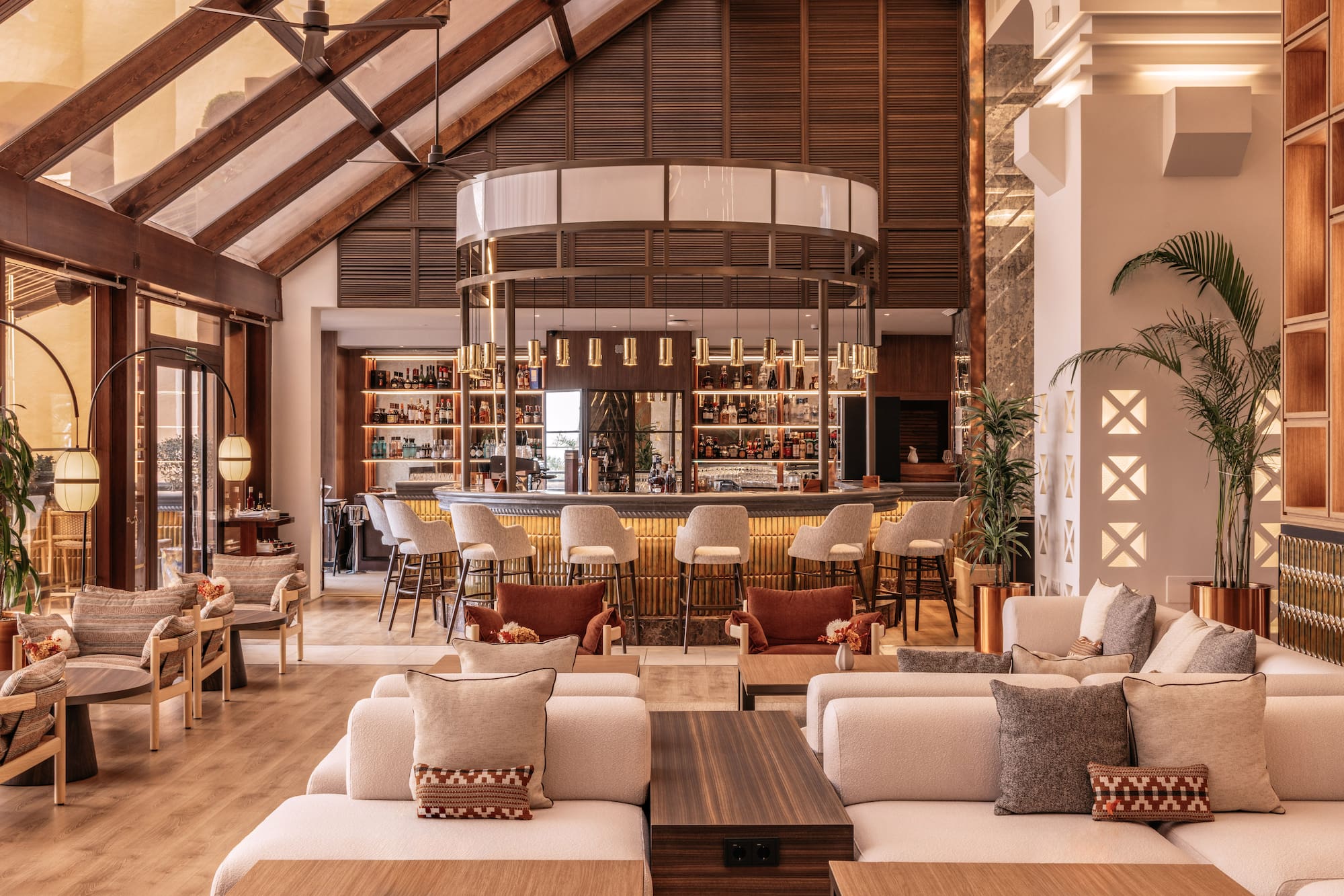 Elegant hotel bar lounge with vaulted ceiling, circular bar, and modern decor.