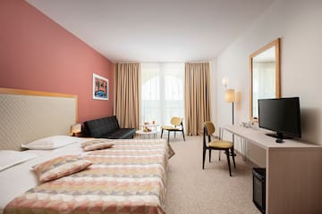a room with a bed and a television