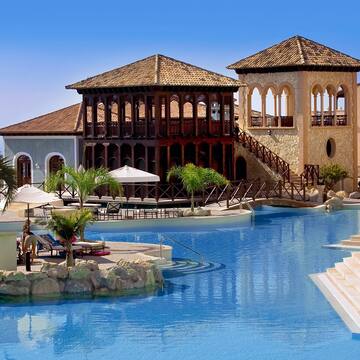 a swimming pool with a building and a beach