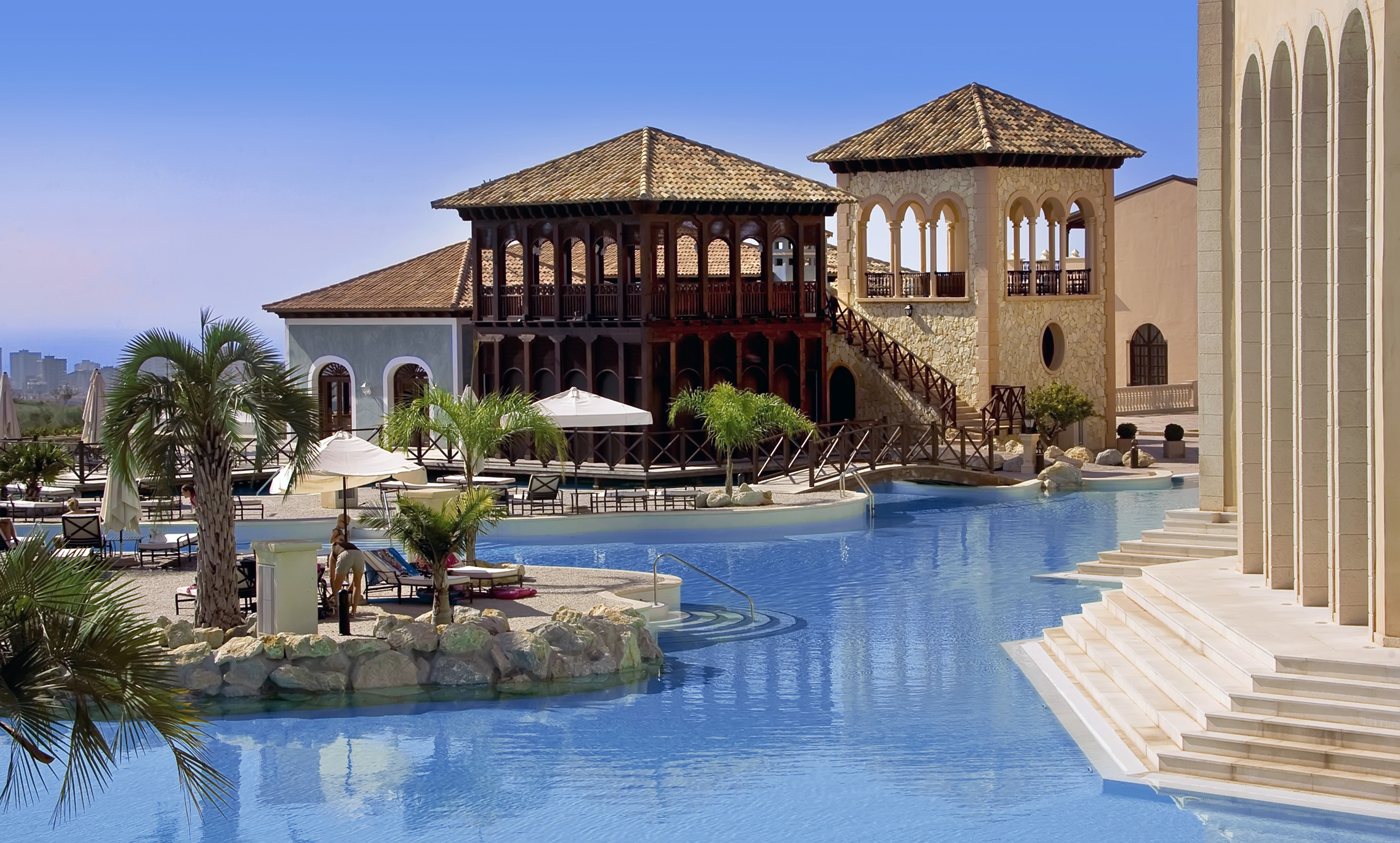 a swimming pool with a building and a beach