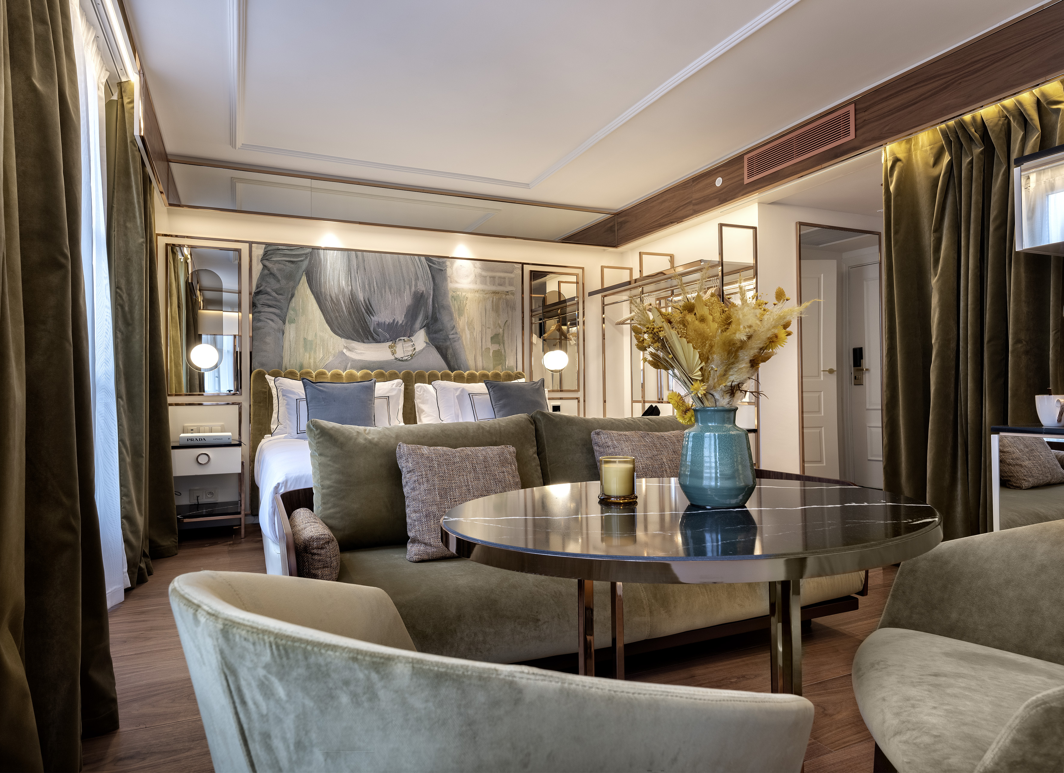Luxurious hotel suite, king bed, sofa, marble table, and rich velvet curtains.