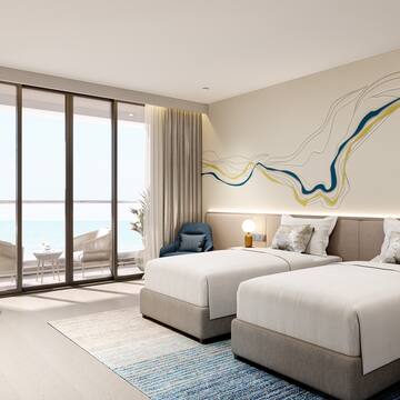 a room with two beds and a view of the ocean