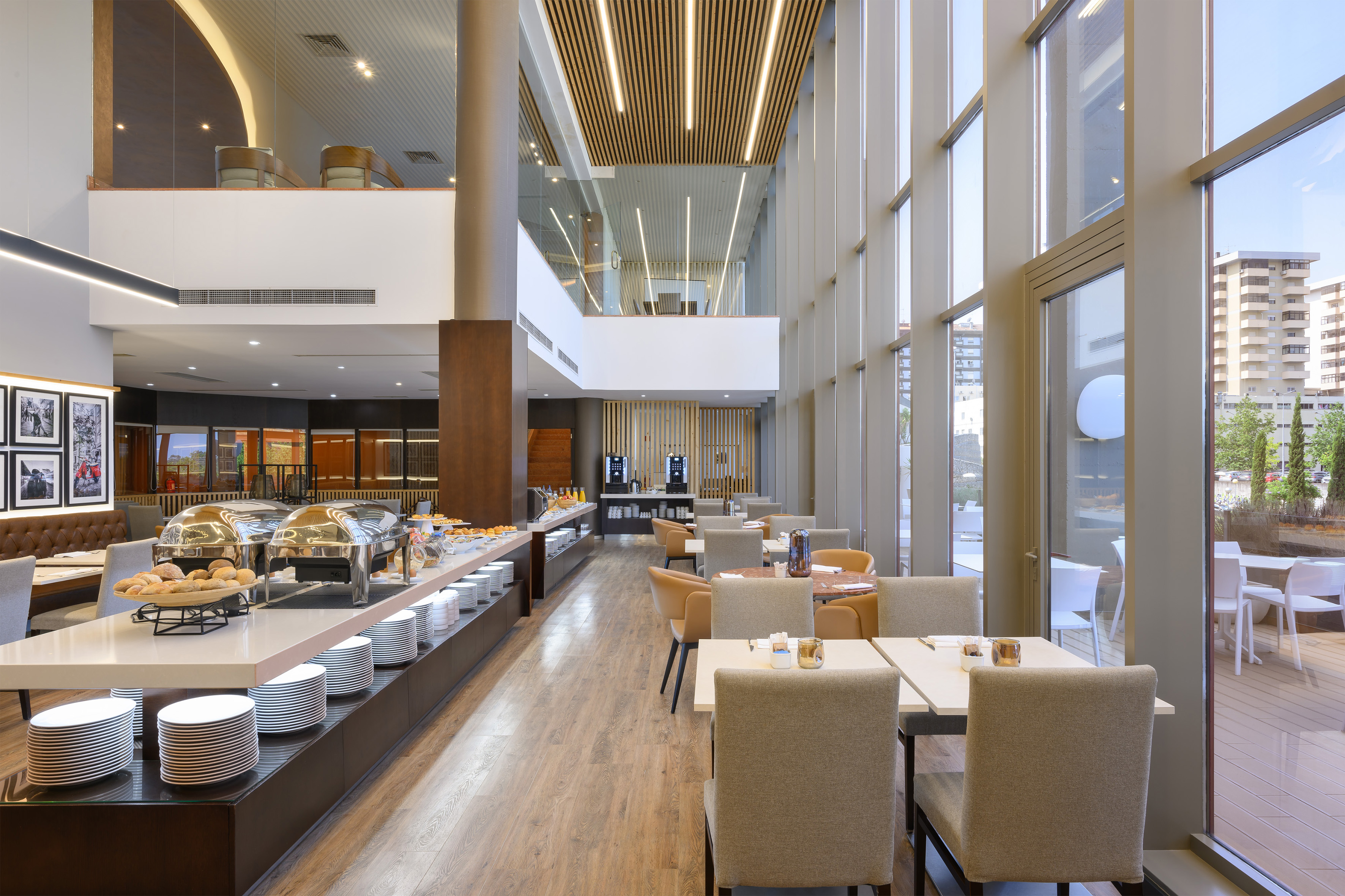 Modern hotel restaurant and buffet with bright natural light and dining tables.