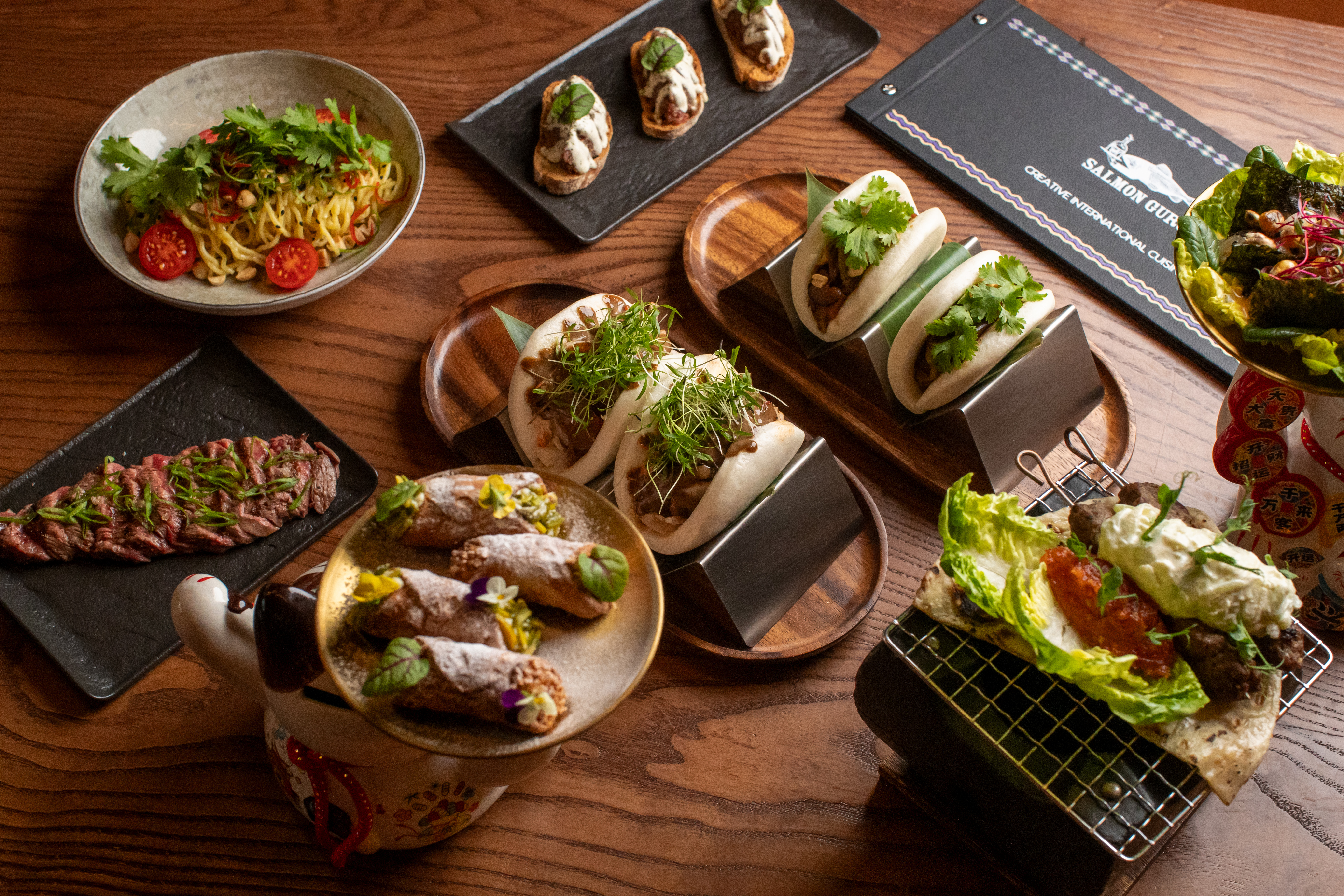 Creative international dishes: bao buns, noodles, beef, cannoli, crostini.