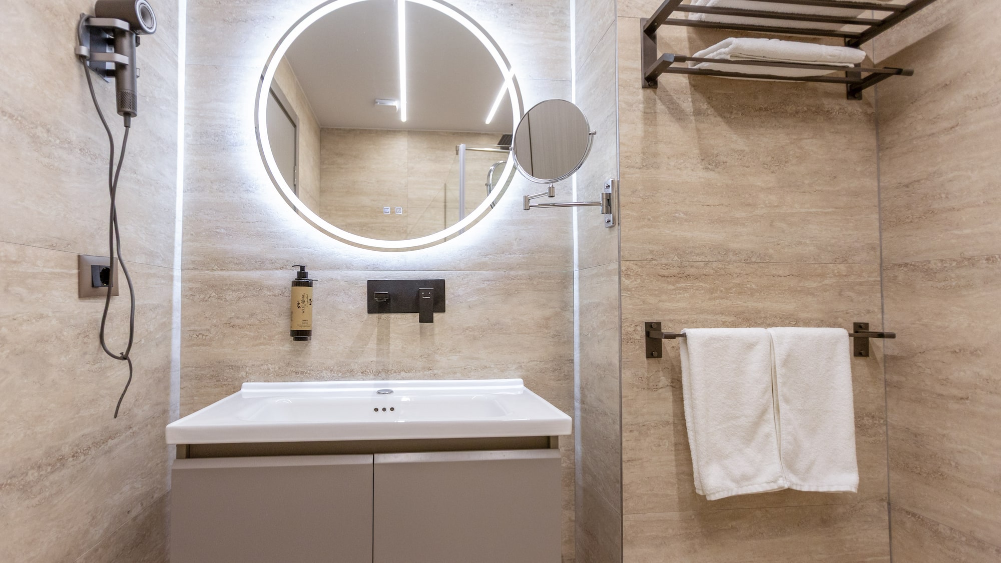 a bathroom with a round mirror and a towel rack
