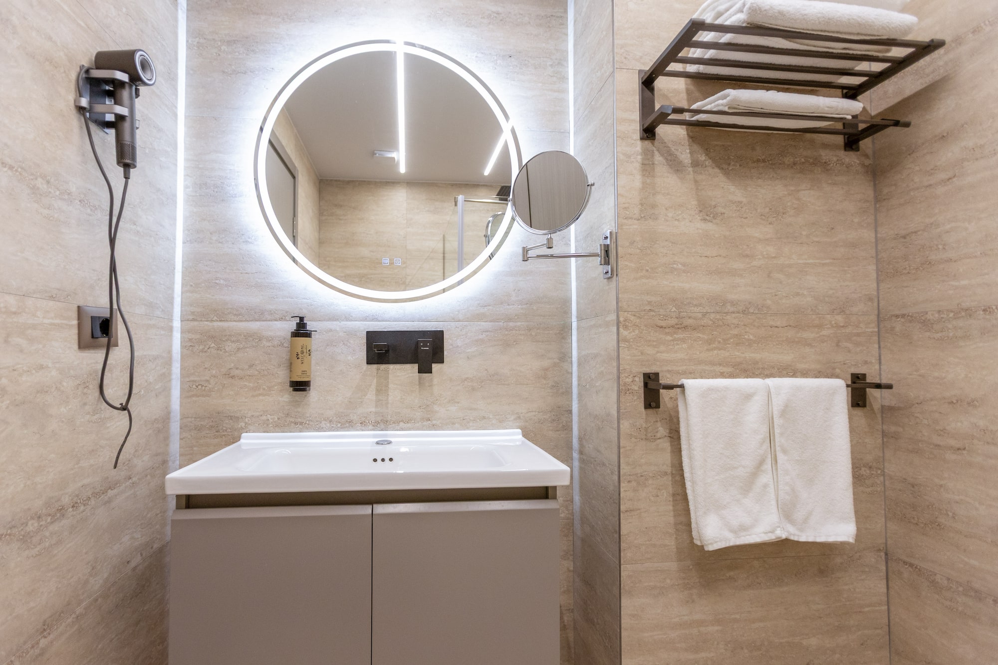 a bathroom with a round mirror and a towel rack