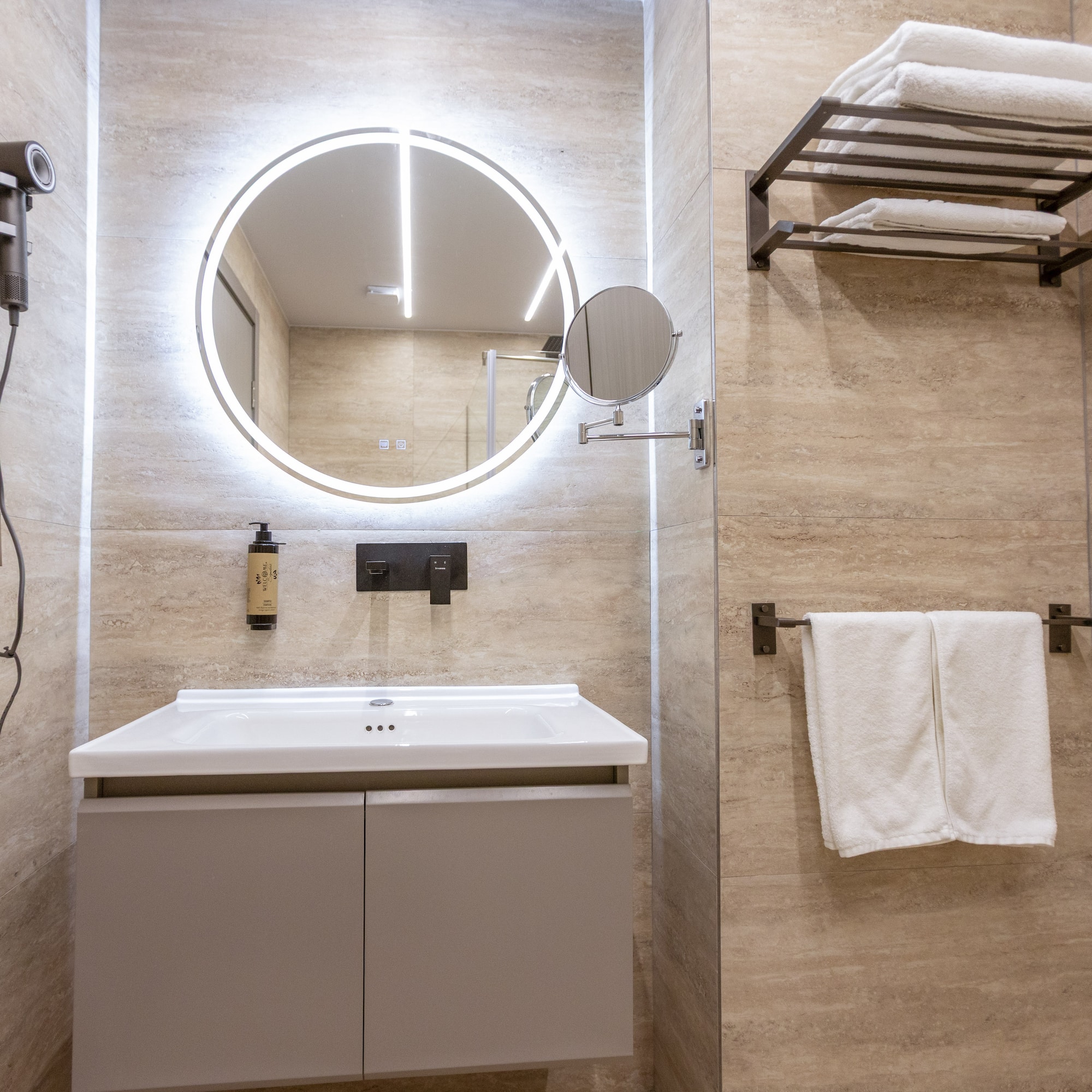 a bathroom with a round mirror and a towel rack