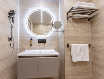 a bathroom with a round mirror and a towel rack