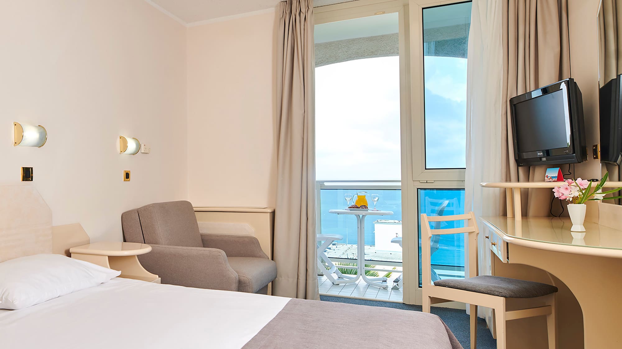 a room with a bed and a desk and chairs