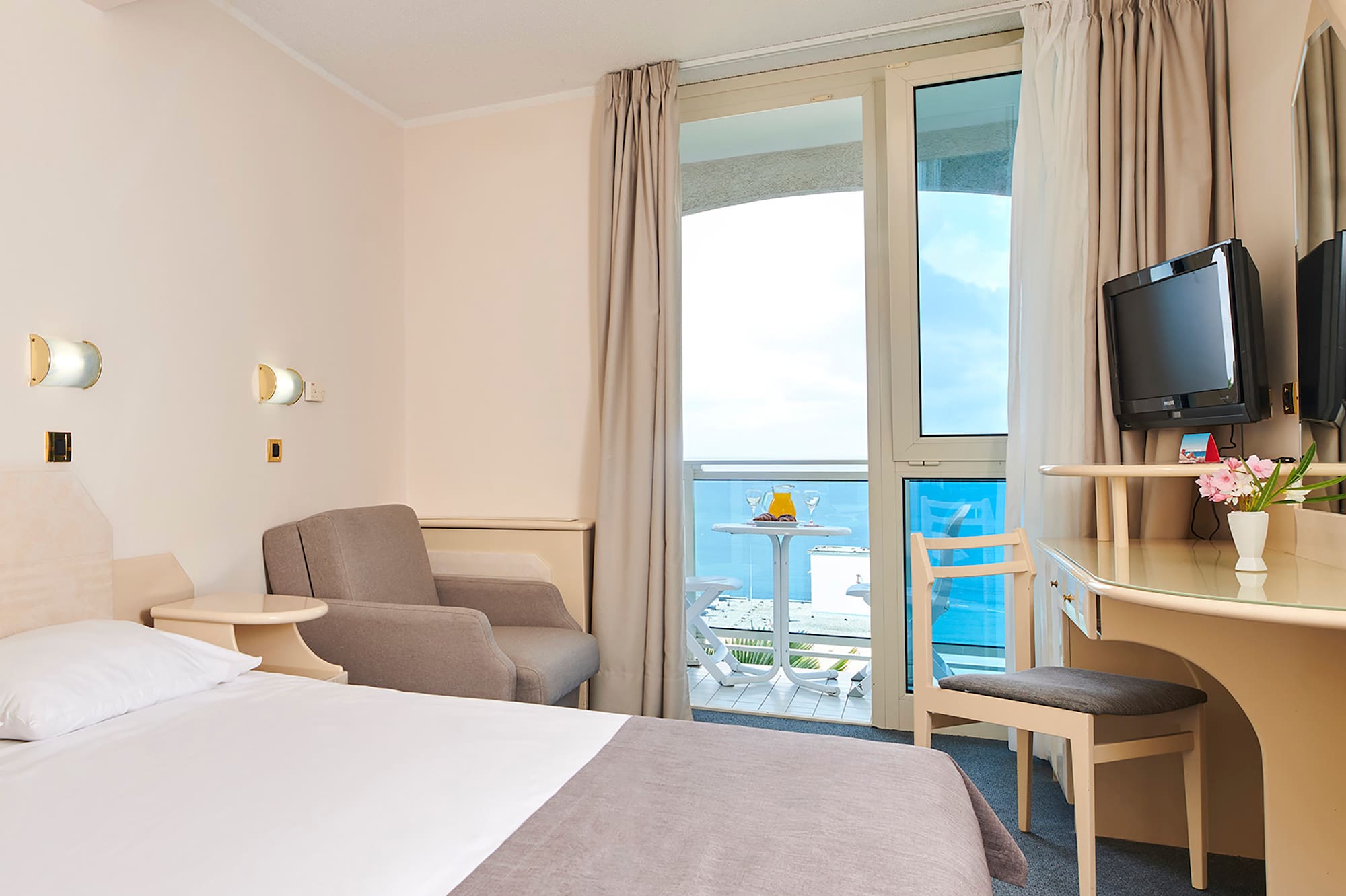 a room with a bed and a desk and chairs