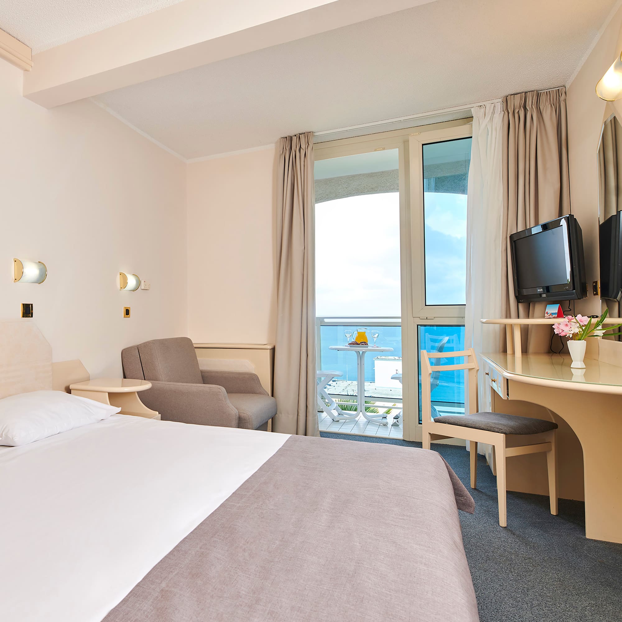 a room with a bed and a desk and chairs