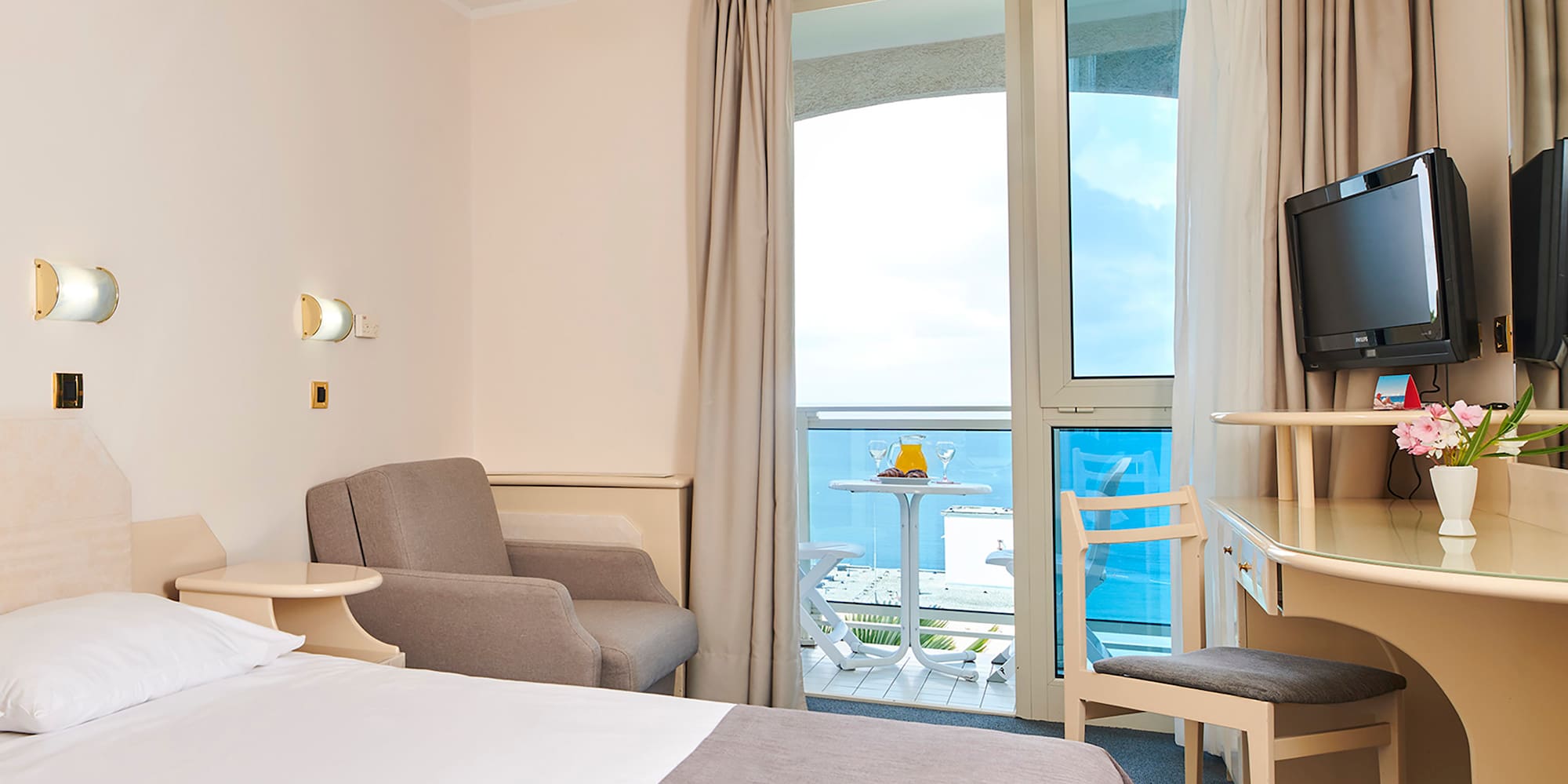 a room with a bed and a desk and chairs