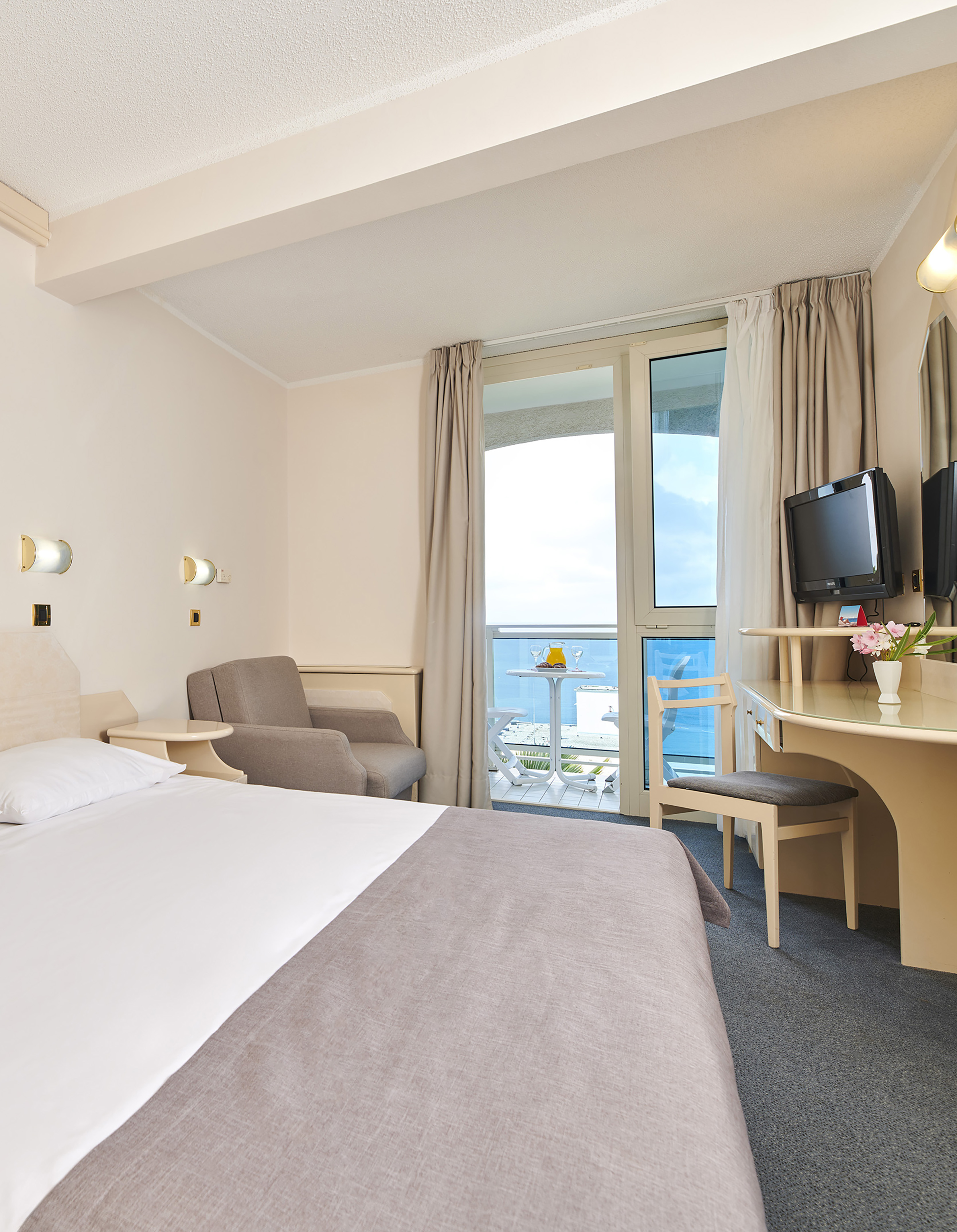 a room with a bed and a desk and chairs