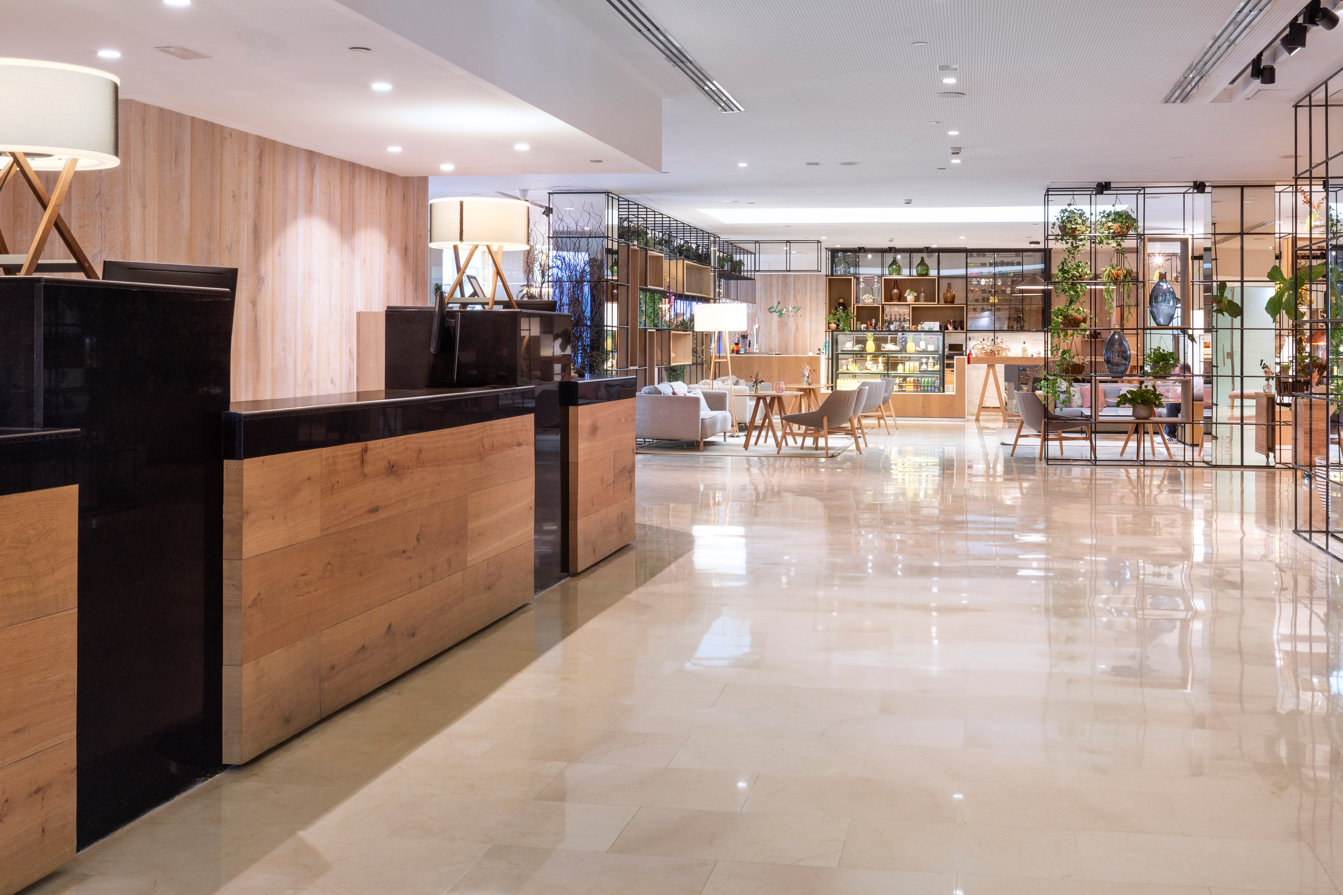Modern hotel lobby with wooden reception desk, lounge area, and contemporary decor.