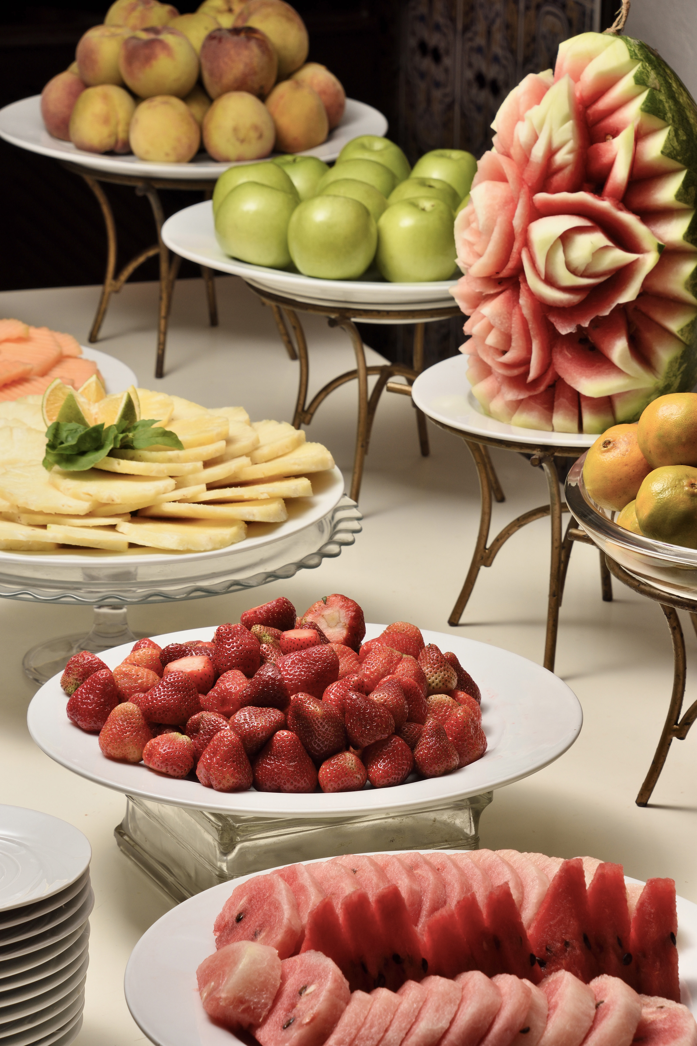 Fresh fruit buffet: strawberries, carved watermelon, pineapple, peaches, green apples.