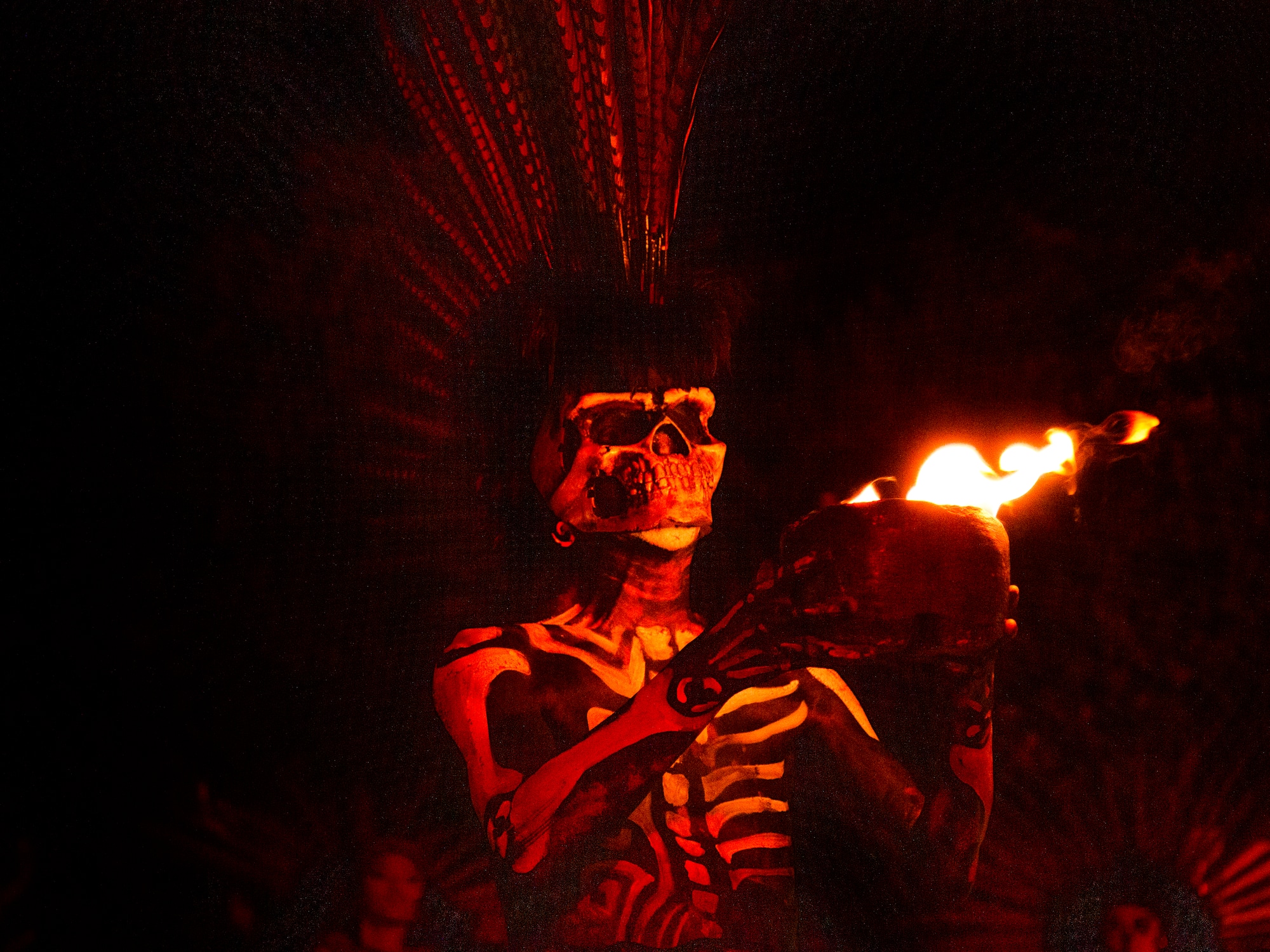 a person in a garment holding a bowl with fire