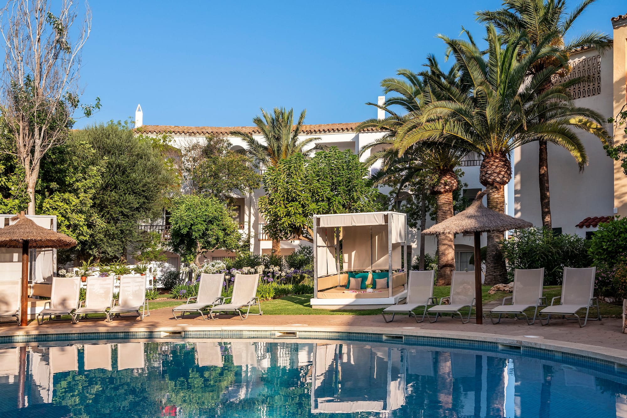 a pool with lounge chairs and trees in the background