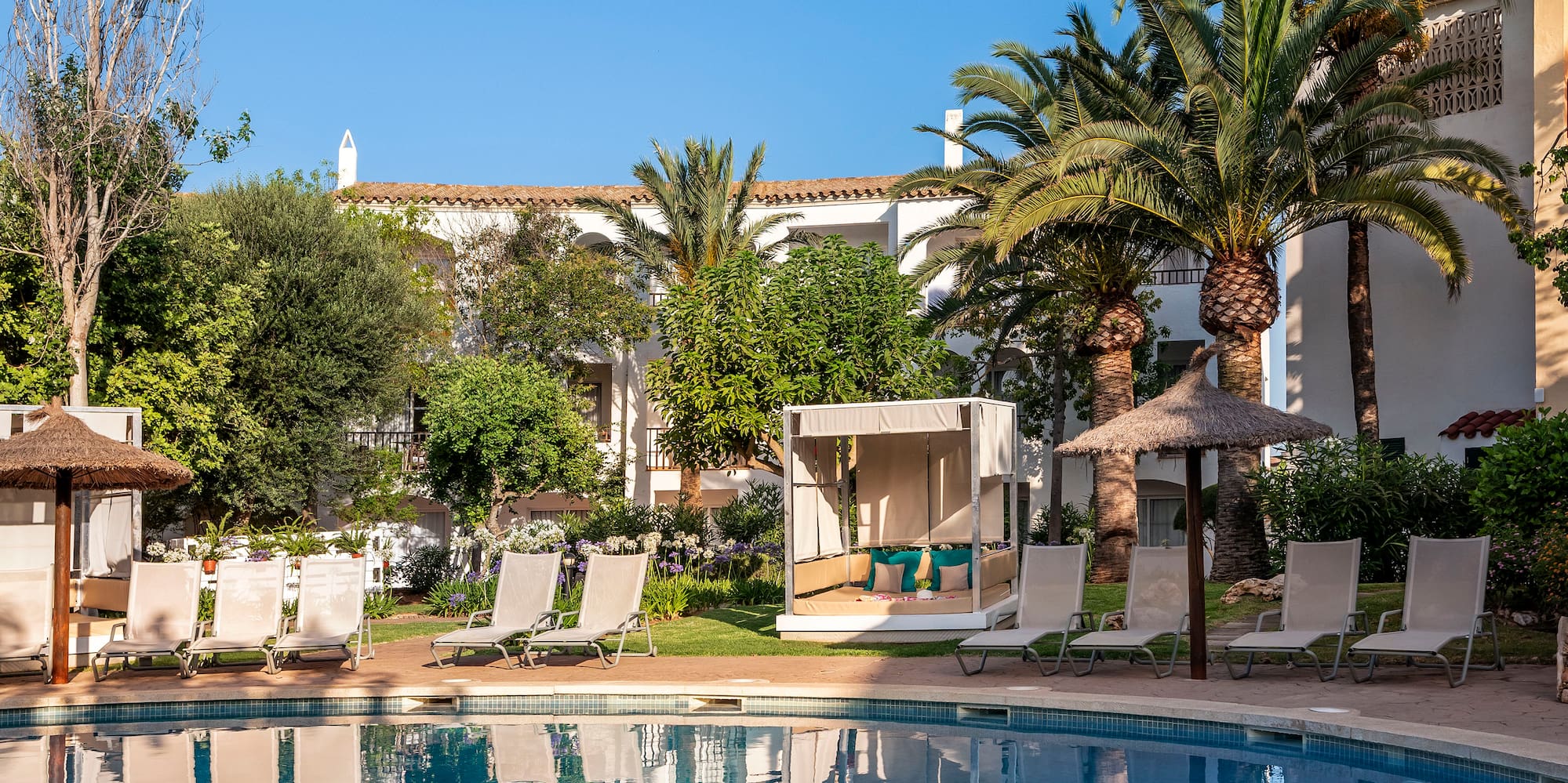 a pool with lounge chairs and trees in the background