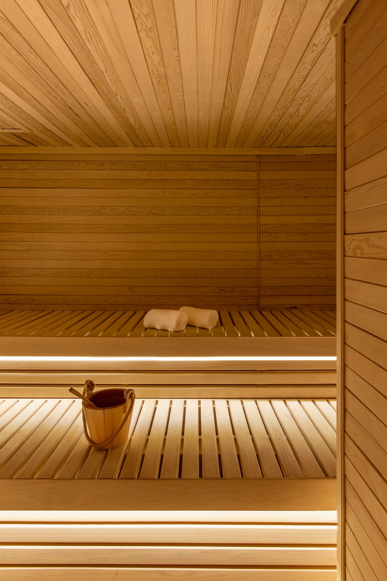 a wooden sauna with bucket and towels