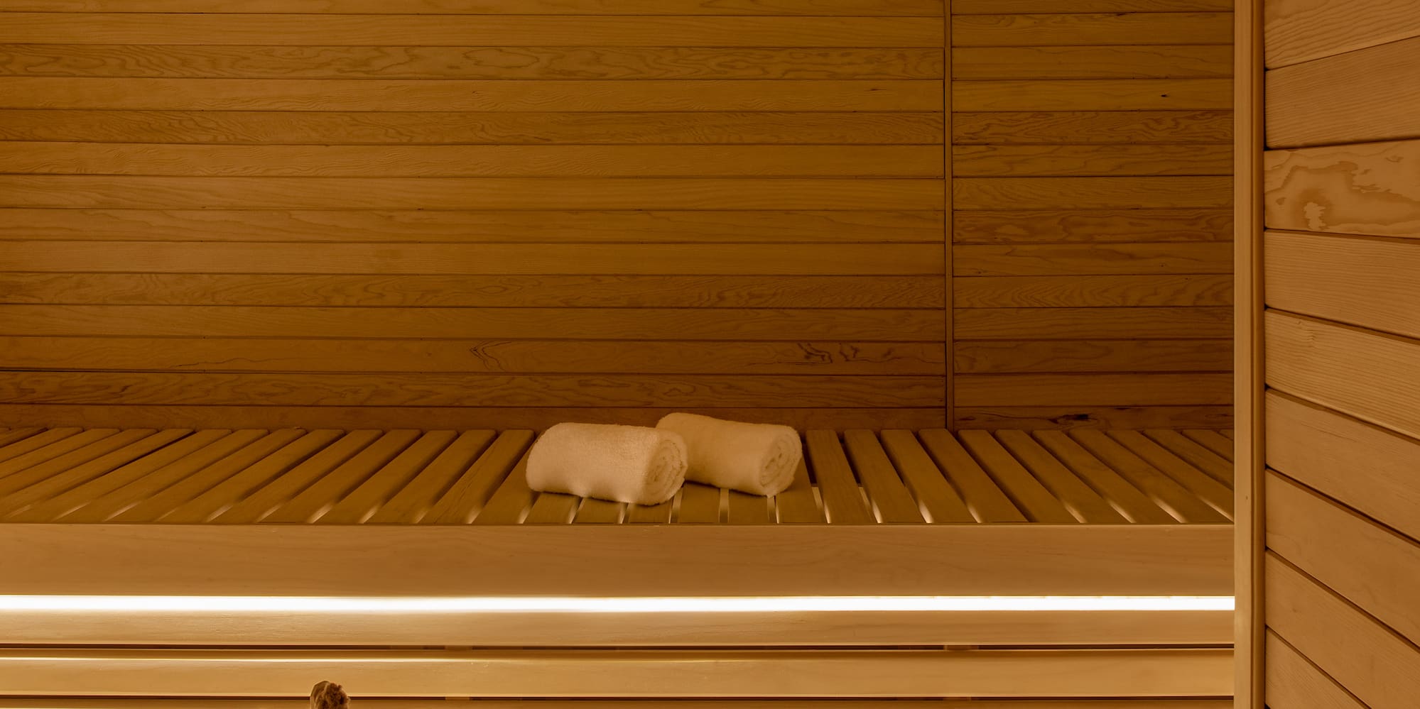 a wooden sauna with bucket and towels