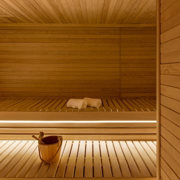 a wooden sauna with bucket and towels