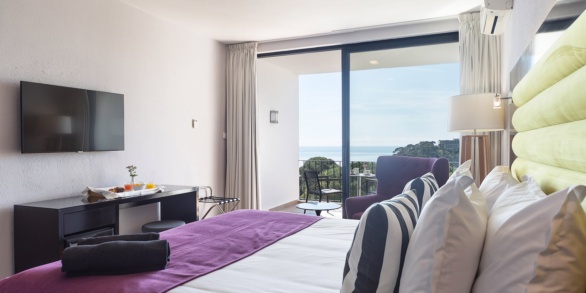 a bedroom with a purple bed and a television