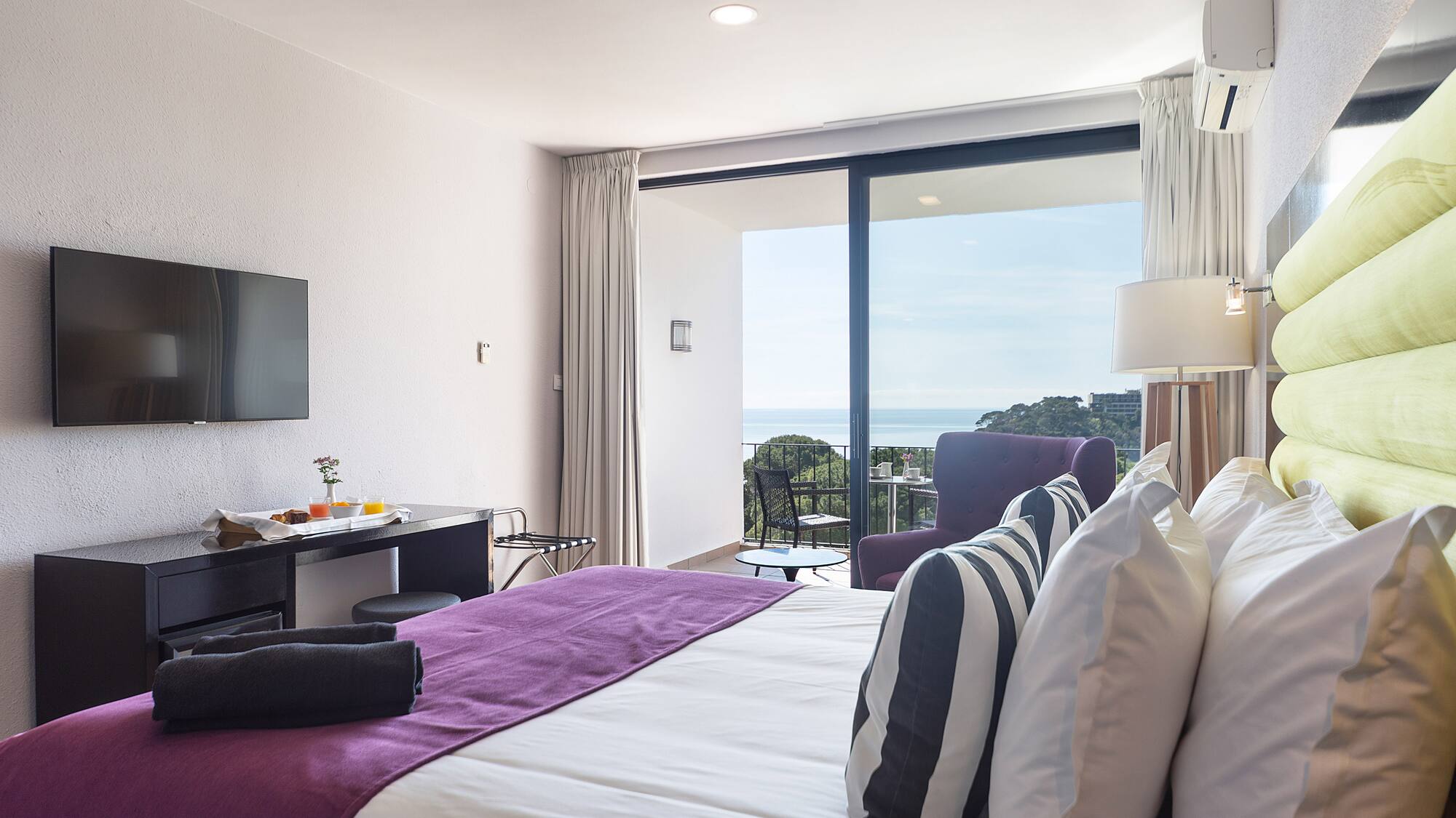 a bedroom with a purple bed and a television