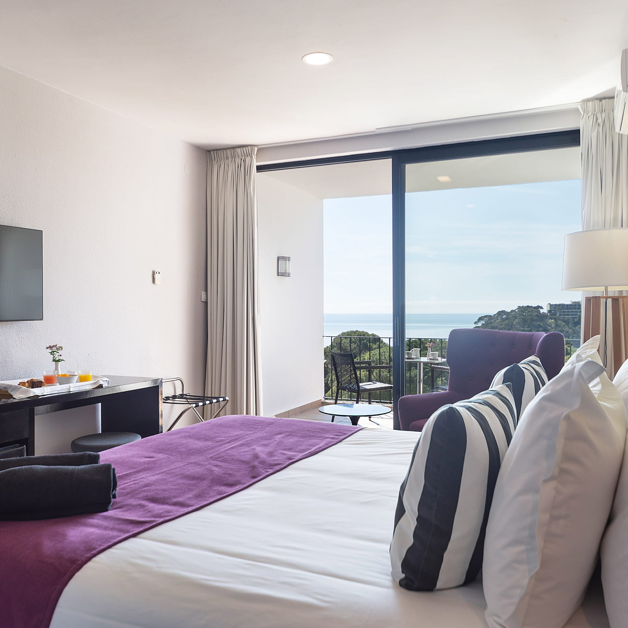 a bedroom with a purple bed and a television