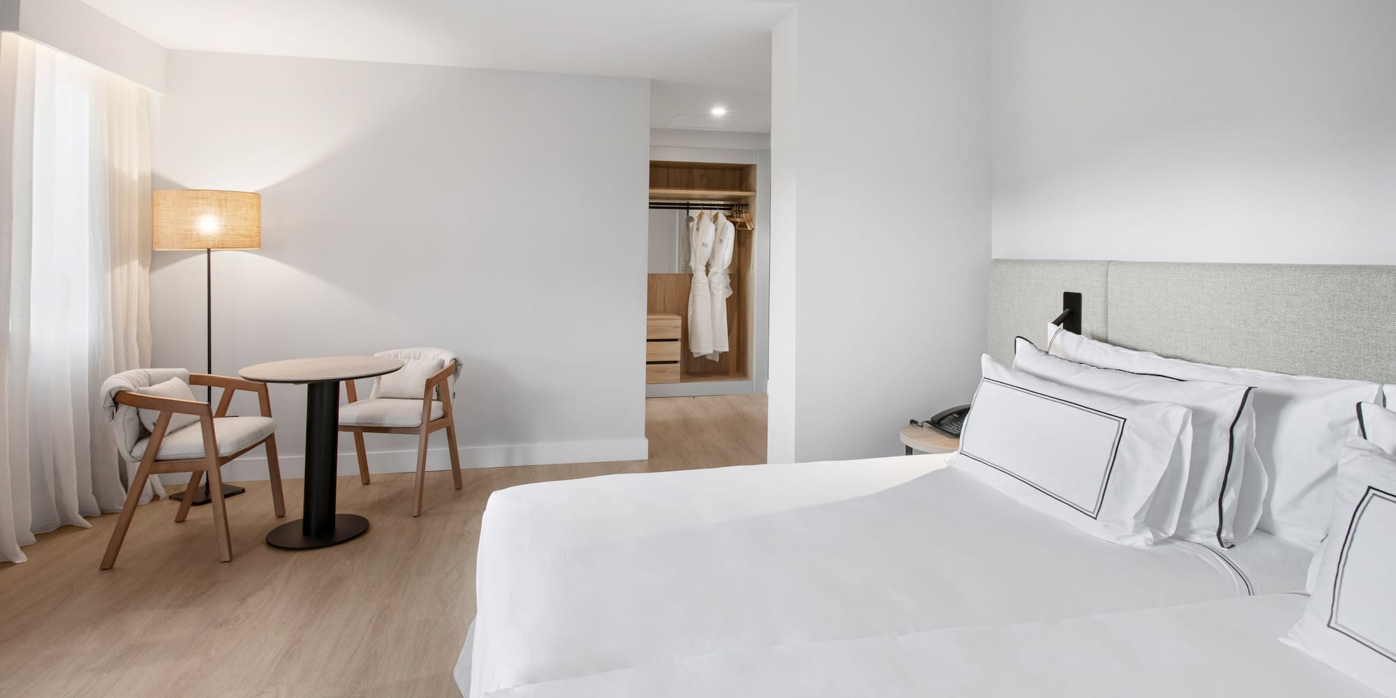 a room with a bed and chairs