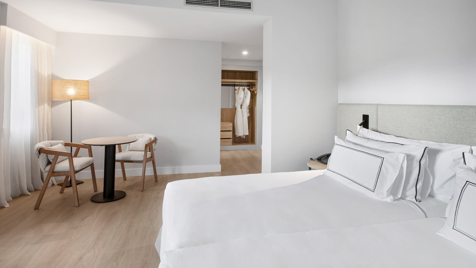 a room with a bed and chairs