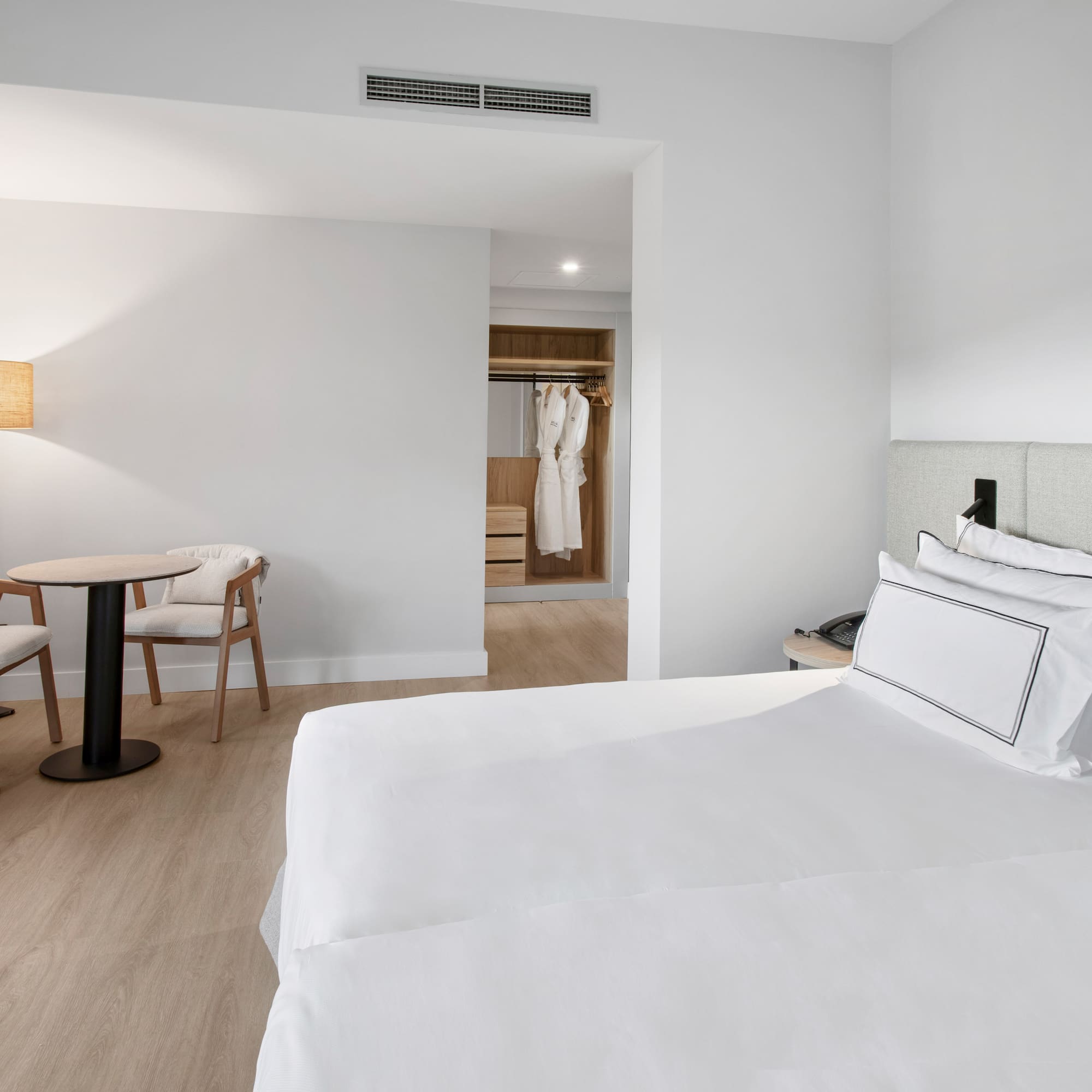 a room with a bed and chairs