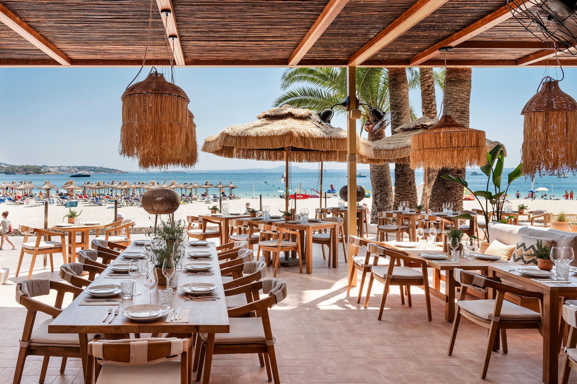 ein Restaurant mit Tischen und Stühlen am Strand