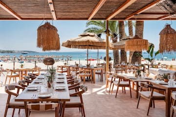 ein Restaurant mit Tischen und Stühlen am Strand