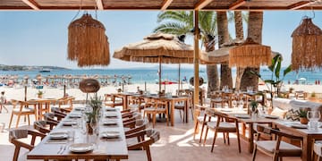 um restaurante com mesas e cadeiras numa praia