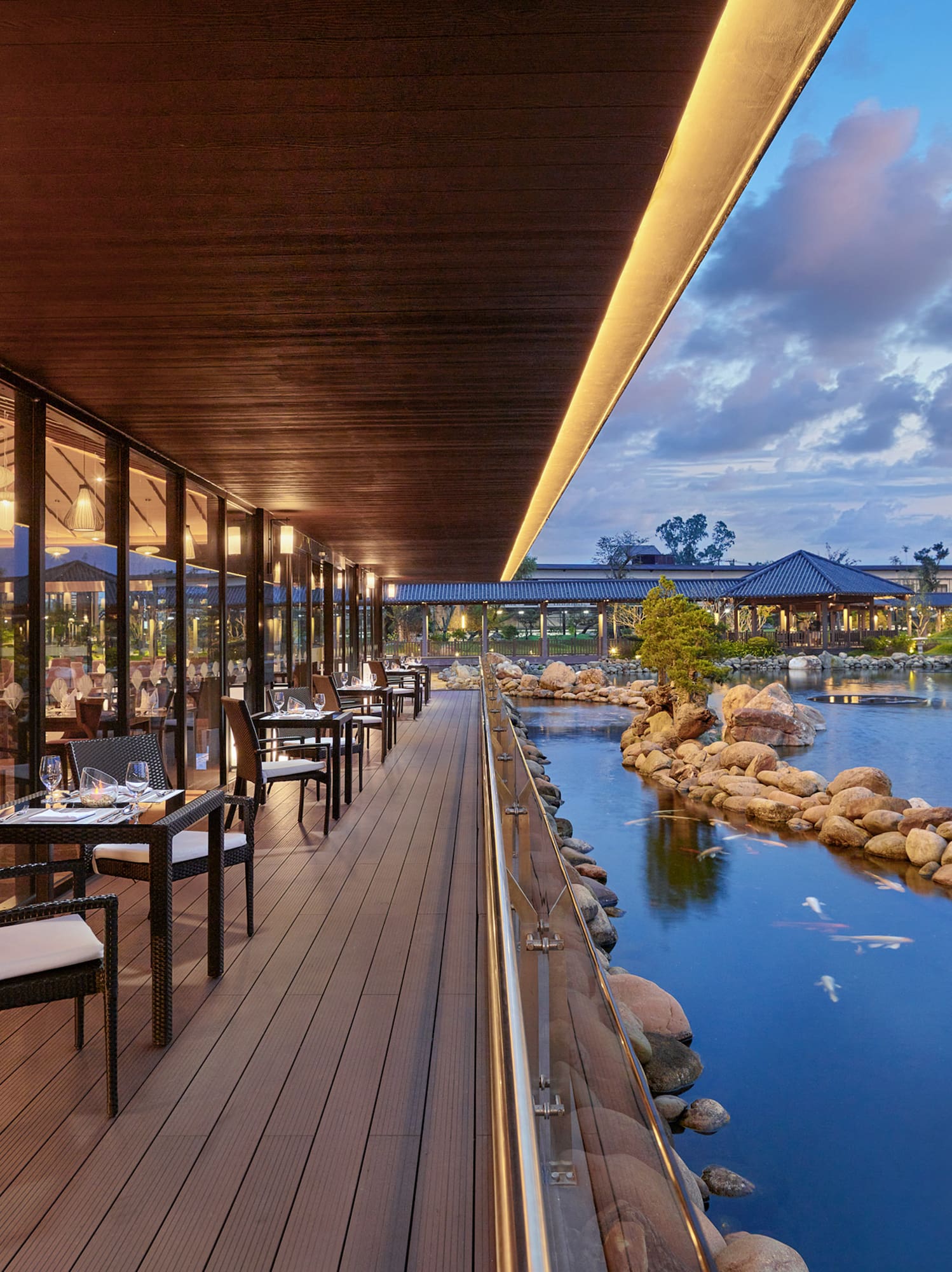 a restaurant with tables and chairs on a deck overlooking a body of water
