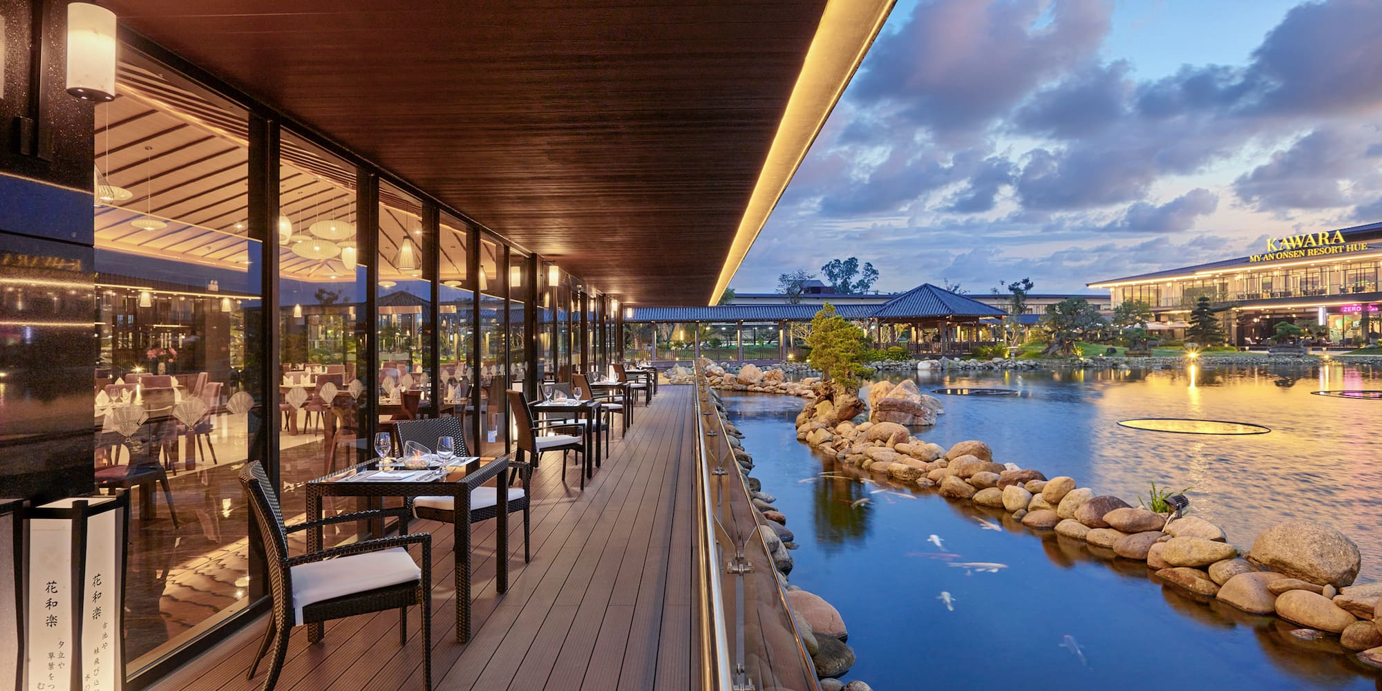 a restaurant with tables and chairs on a deck overlooking a body of water